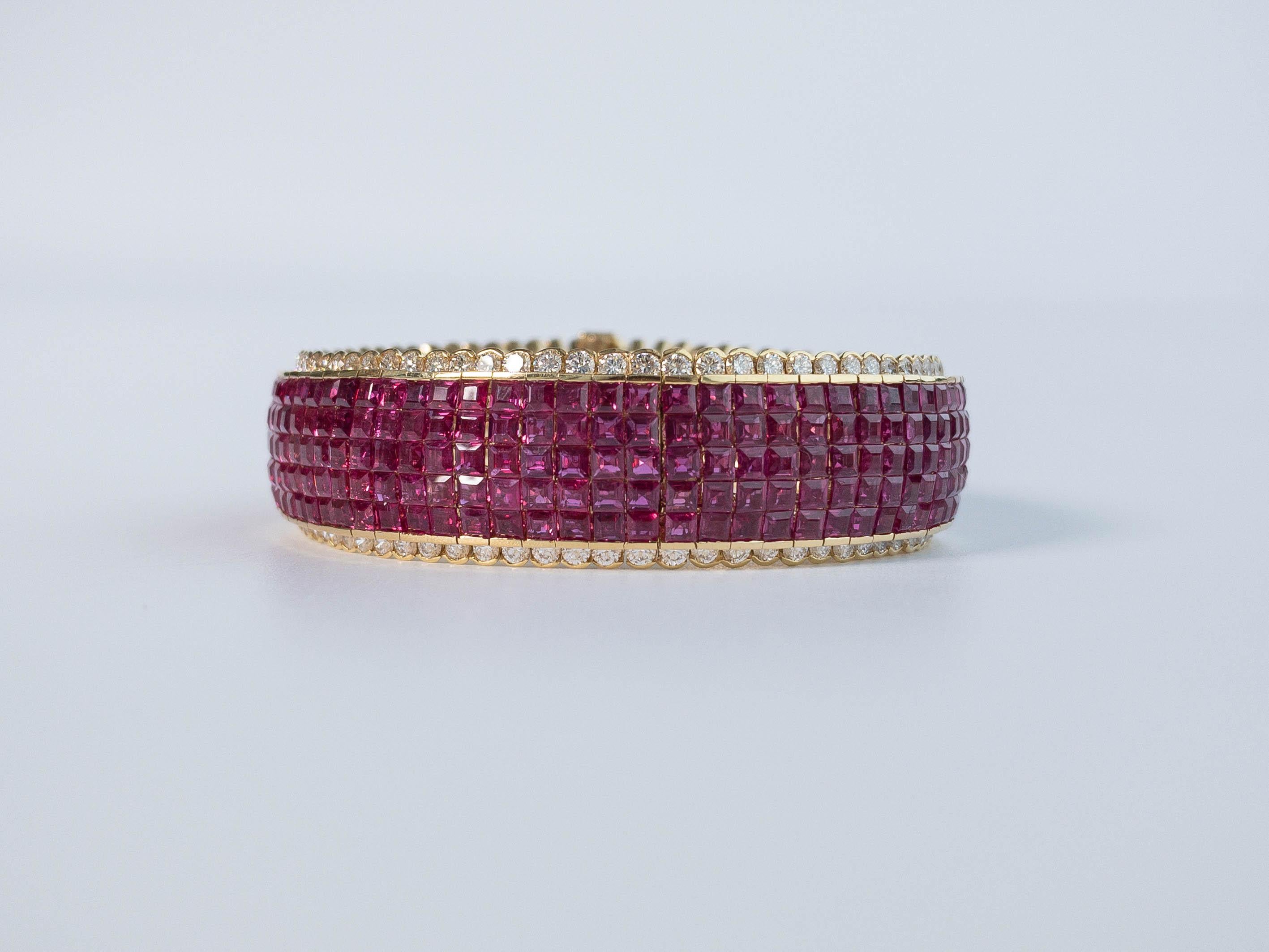 A classic yellow gold invisible set ruby and diamond bracelet.  This piece houses an impressive 370 pieces of natural square cut rubies in five rows of invisible setting surrounded by 148 bezel set round white diamonds. 

Ruby 370 pcs.
Size 2.5