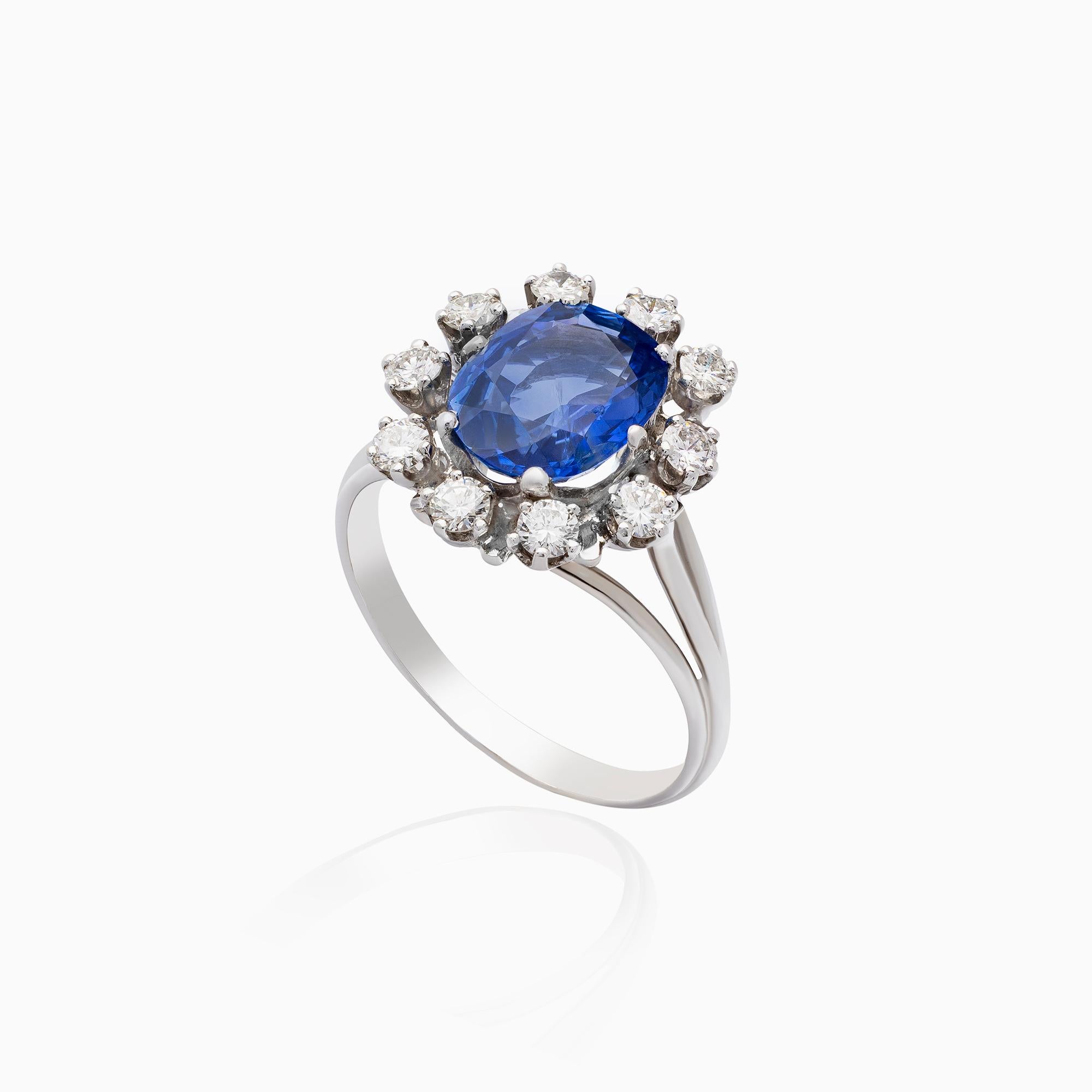 Bague saphir, 3,30 carats, bague diamant, 0,70 carats, or blanc 14K, design halo. Cette bague raffinée est réalisée en or blanc 14 carats et présente un saphir bleu naturel de taille ovale pesant environ 3,30 carats. La pierre précieuse présente une