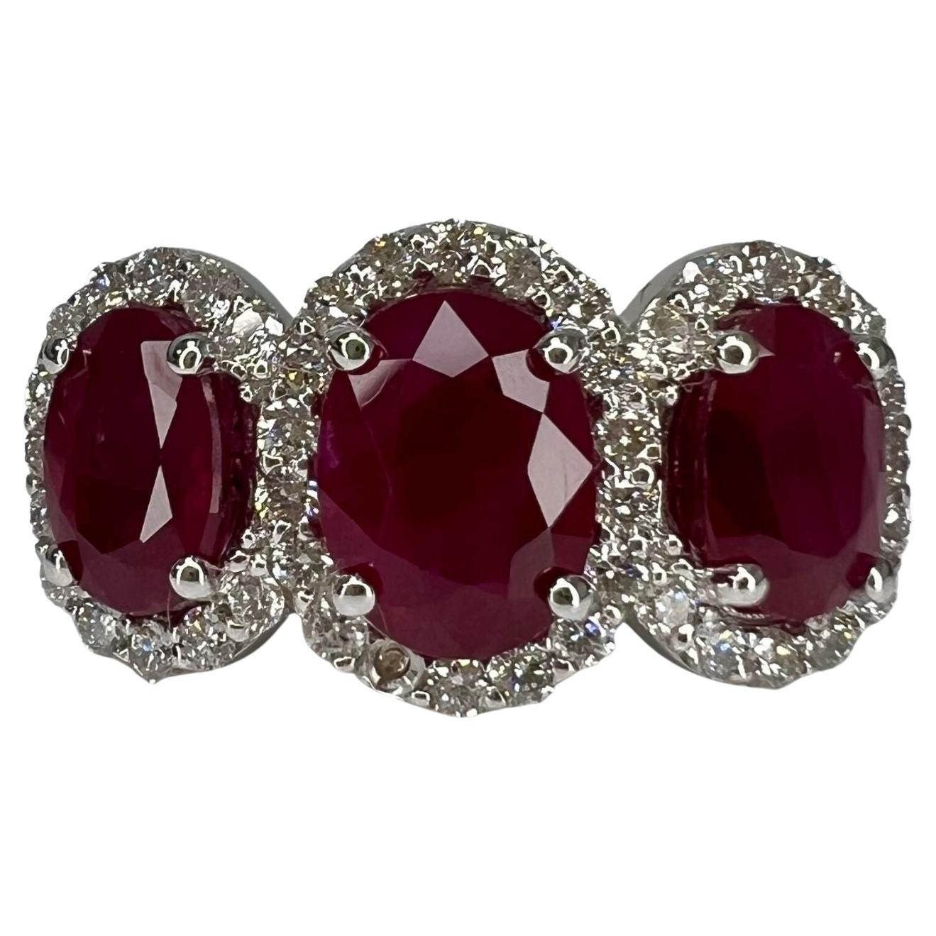 3.30 Carat Ruby Oval Three Stone Halo Ring For Sale