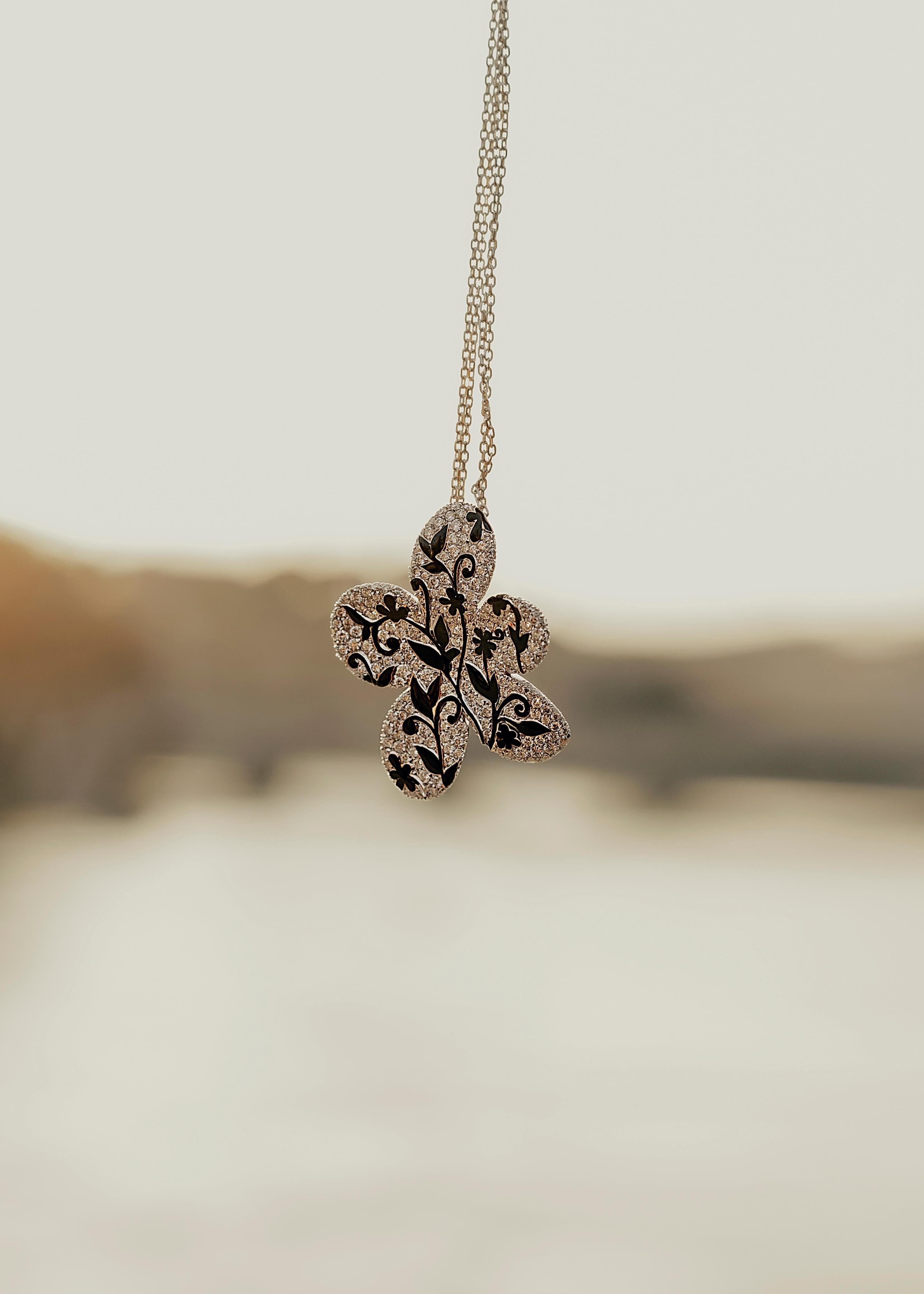 Loosely inspired by Van Gogh's flower paintings, this 18kt white gold necklace features a double chain and a flat, diamond-pavé flower pendant. A black flower painting adds a modern touch to the small piece of art.

The flowers paintings had a