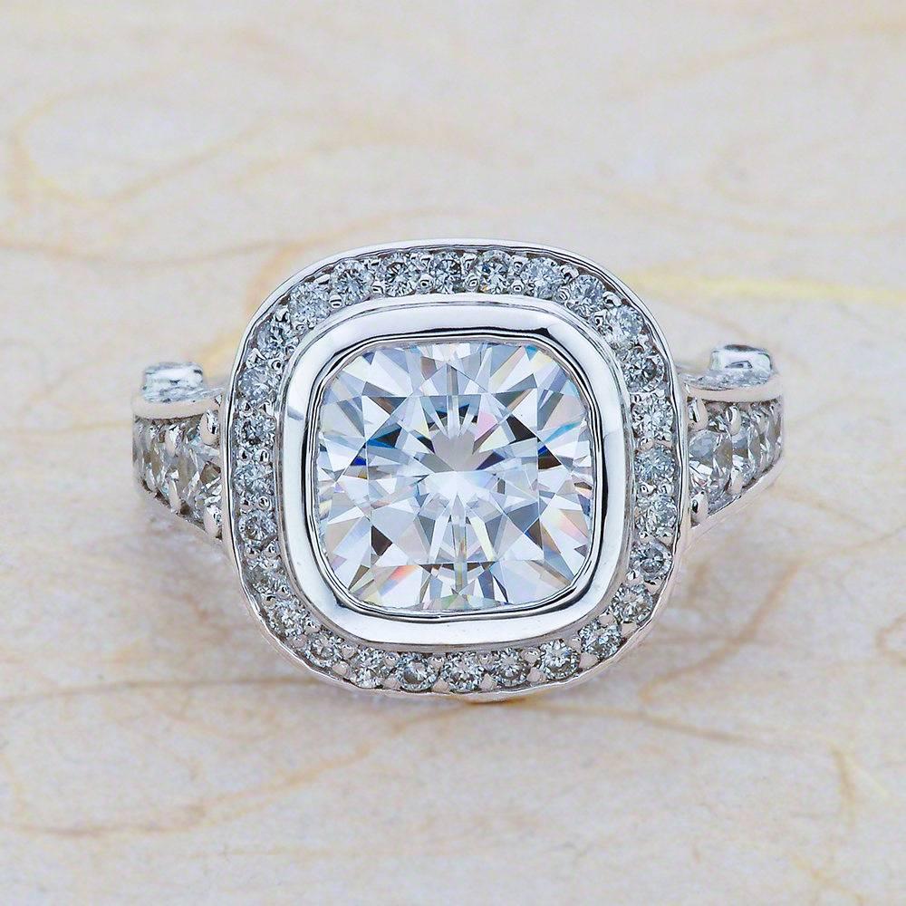 - Center Stone: Cushion Cut Moissanite 9x9mm (3.30ct)
- Side Stones: Round Cut Diamonds 1.25ctw / Graded G SI1
- Metal: 14K White Gold

This piece is made-to-order. Please allow up to 7 Business Days to accomplish.