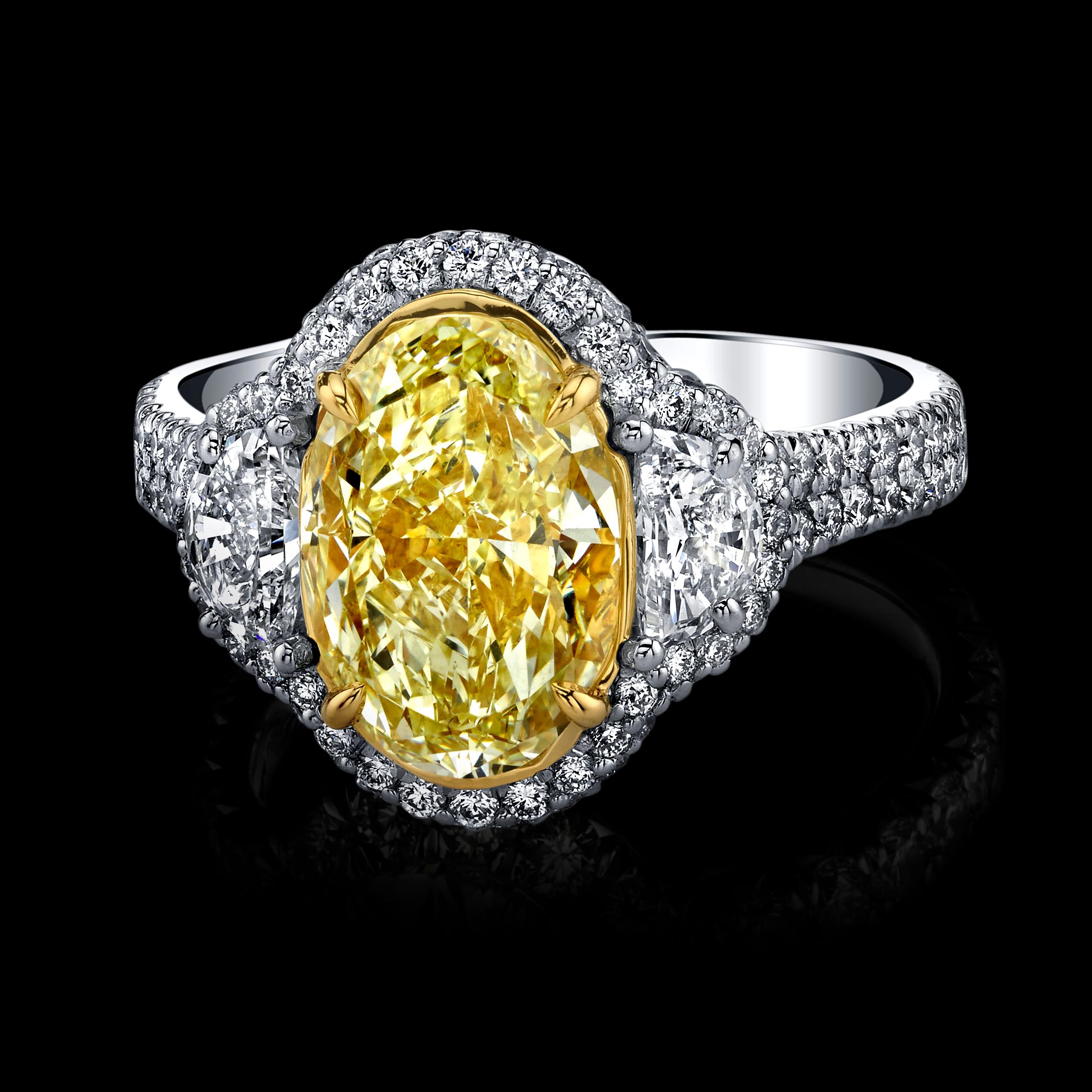 A fabulous 3.30ct Oval Fancy Yellow Natural Diamond with 2 Colorless Half Moon Shapes totaling 0.55cts and a Halo of Natural Round Colorless Diamonds totaling 0.90cts.

This diamond is EGL certified.