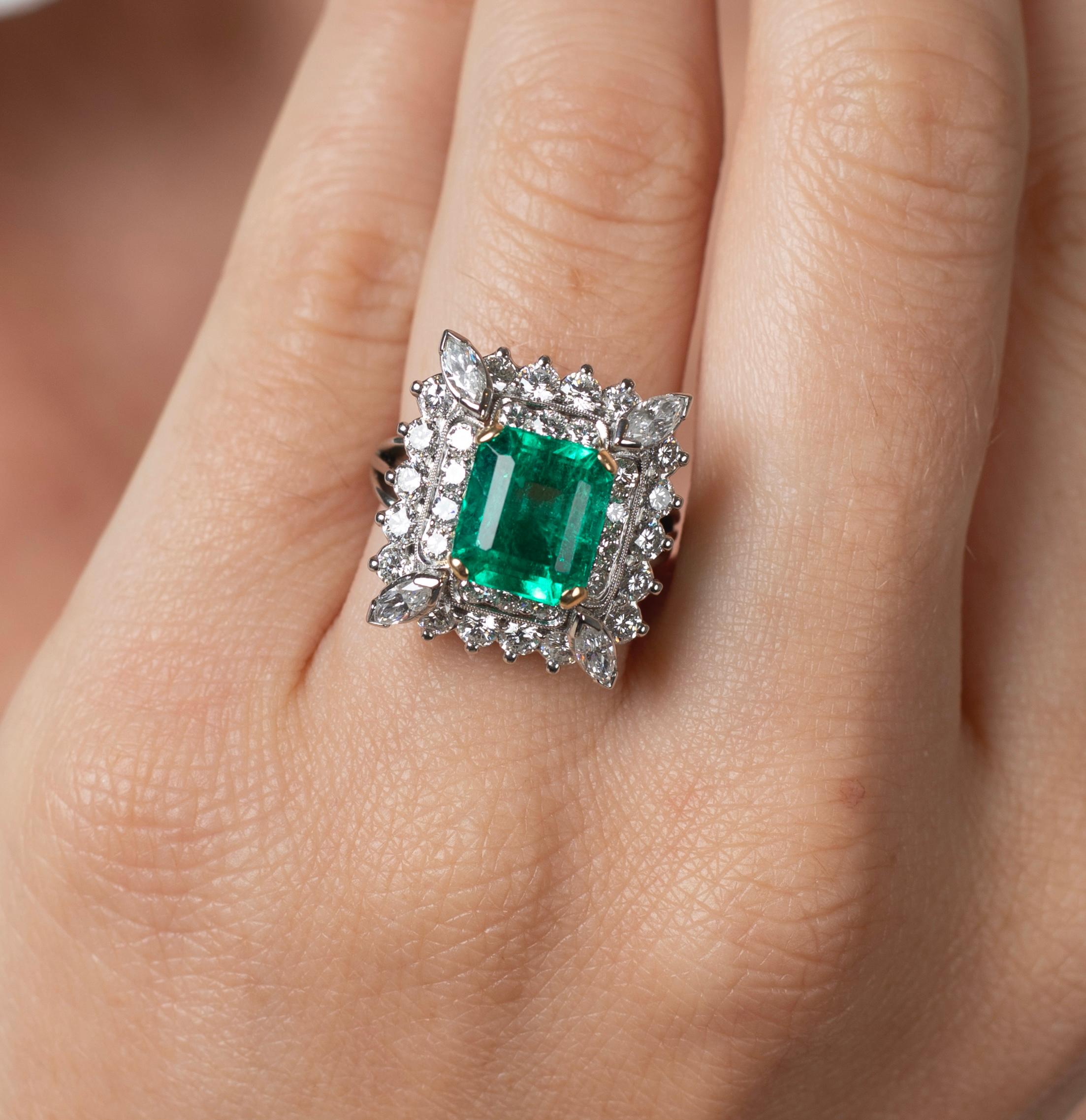 3.31 Carat vivid green natural Emerald center stone mounted with 2 carats in diamonds and set in platinum. Signed 