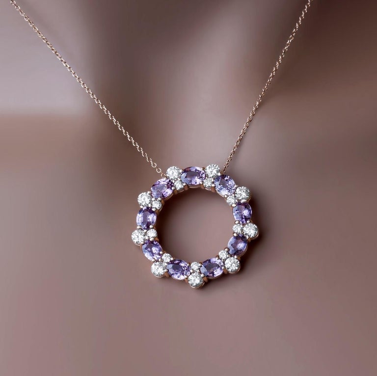 This beautiful circle pendant set in 14k pink gold has a series of oval pink sapphires, total 3.31 carats, alongside pairs of round white diamonds. The total diamond weight is 1.29 carats. This piece can be customized to different metals and