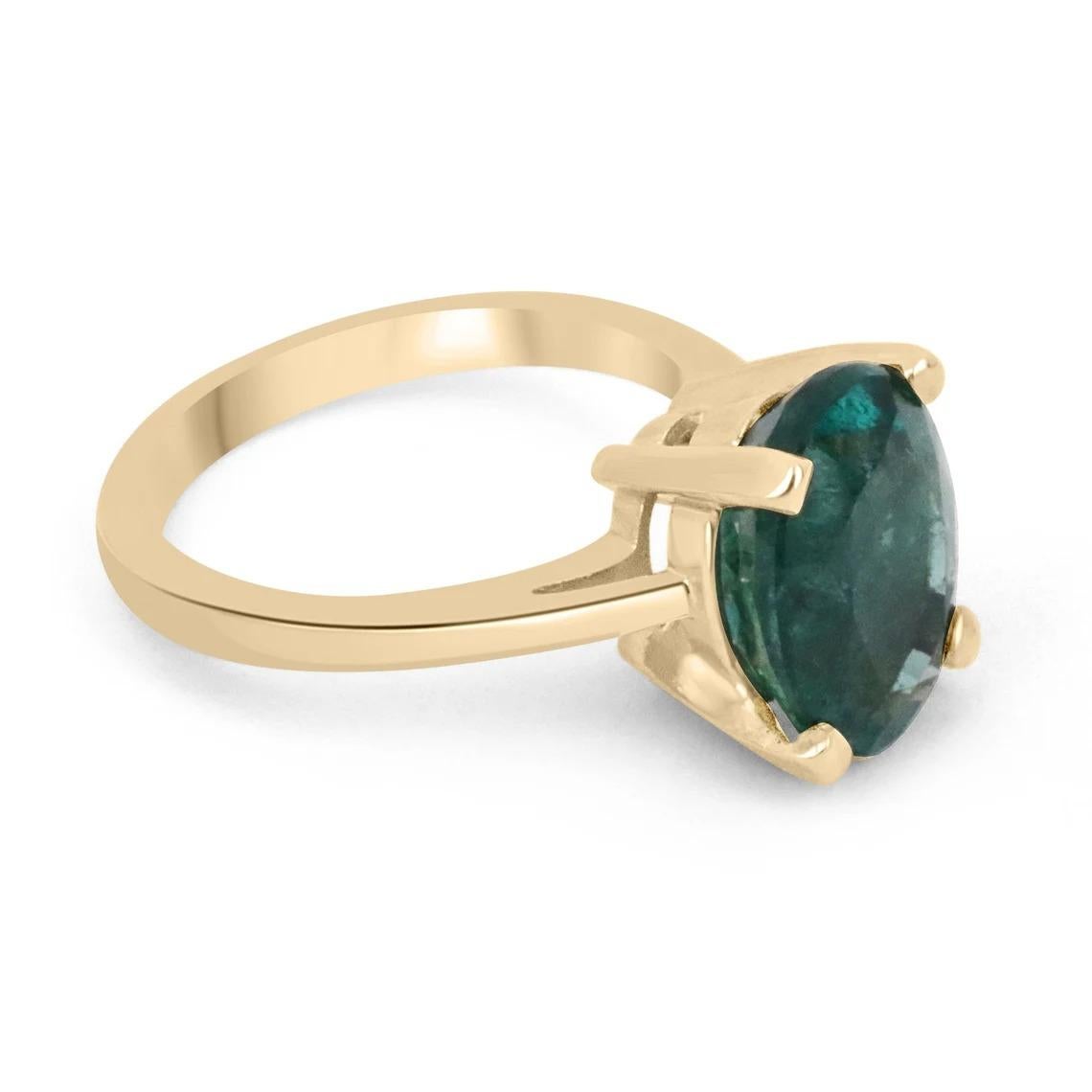 A gorgeous solitaire emerald ring. This beautiful piece showcases a large 3.31-carat, natural, Zambian oval cut emerald. The gemstone has a lustrous, dark forest green color with a deep bluish-green hue. Set in a simple, four-prong 14K yellow gold