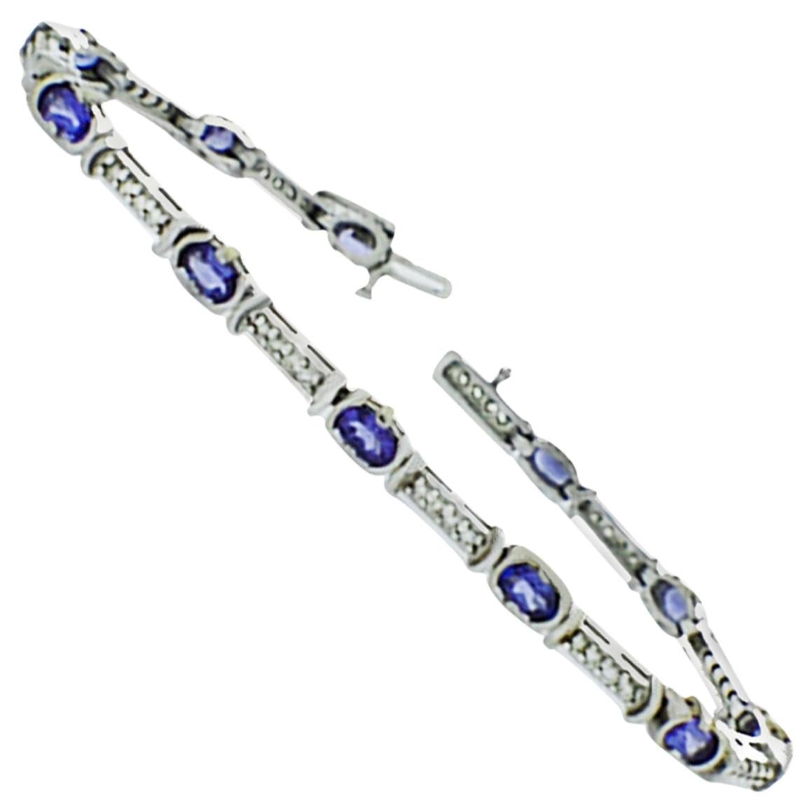 
Diamond and Tanzanite, Tennis Bracelet designed as a link style with tube -Set gemstones set in a 14 Karat white gold setting.
Total 7 inches in length tennis bracelet has alternating tanzanite and diamonds. 

(11) oval shaped Tanzanite gemstones