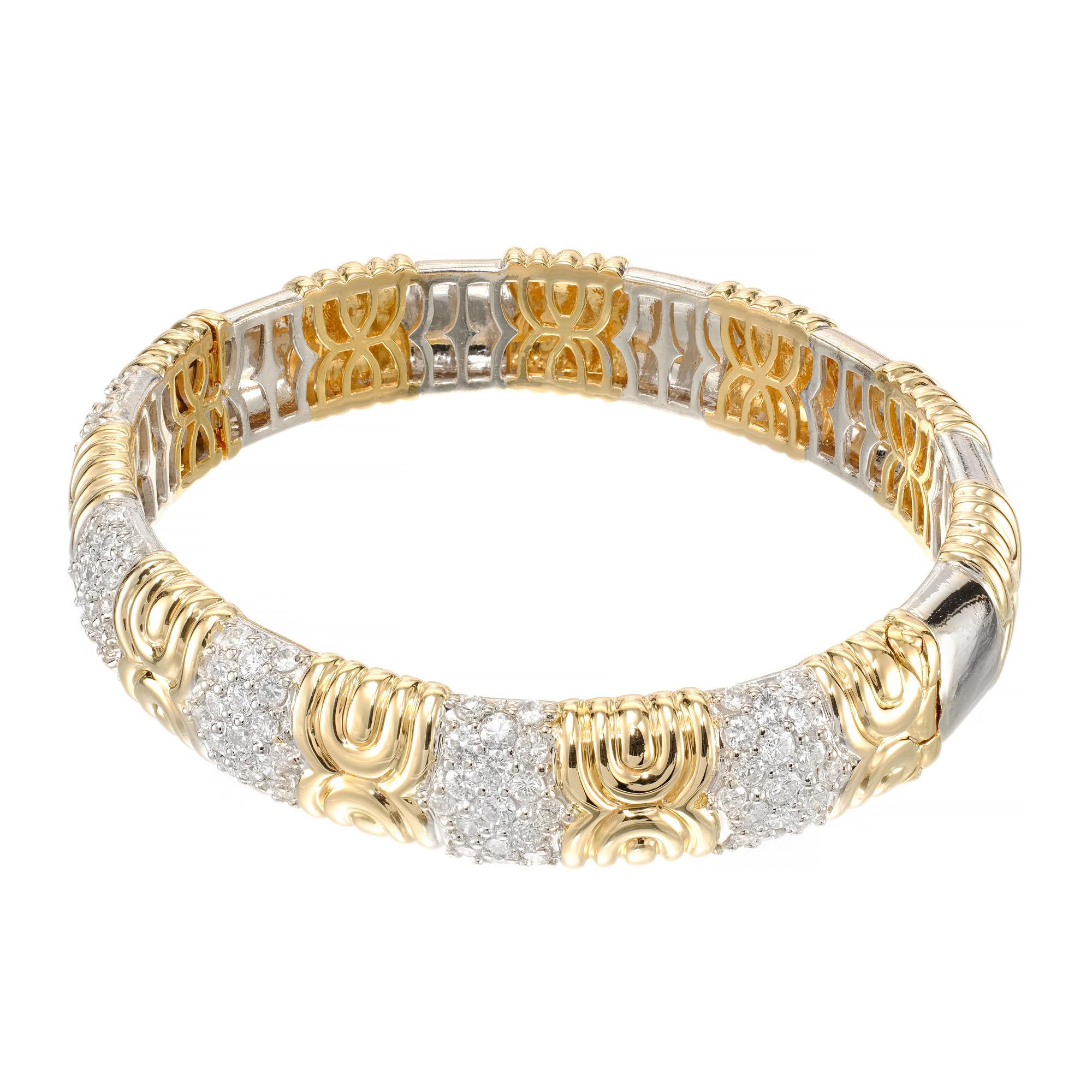 18k yellow and white gold bangle bracelet accented with 95 round brilliant cut diamonds.

95 round brilliant cut diamonds, G-H VS approx. 3.33cts
18k yellow gold 
18k white gold 
Stamped: 750
50.3 grams
Width: 12.6mm 
Thickness/depth: 5.7mm
Inside