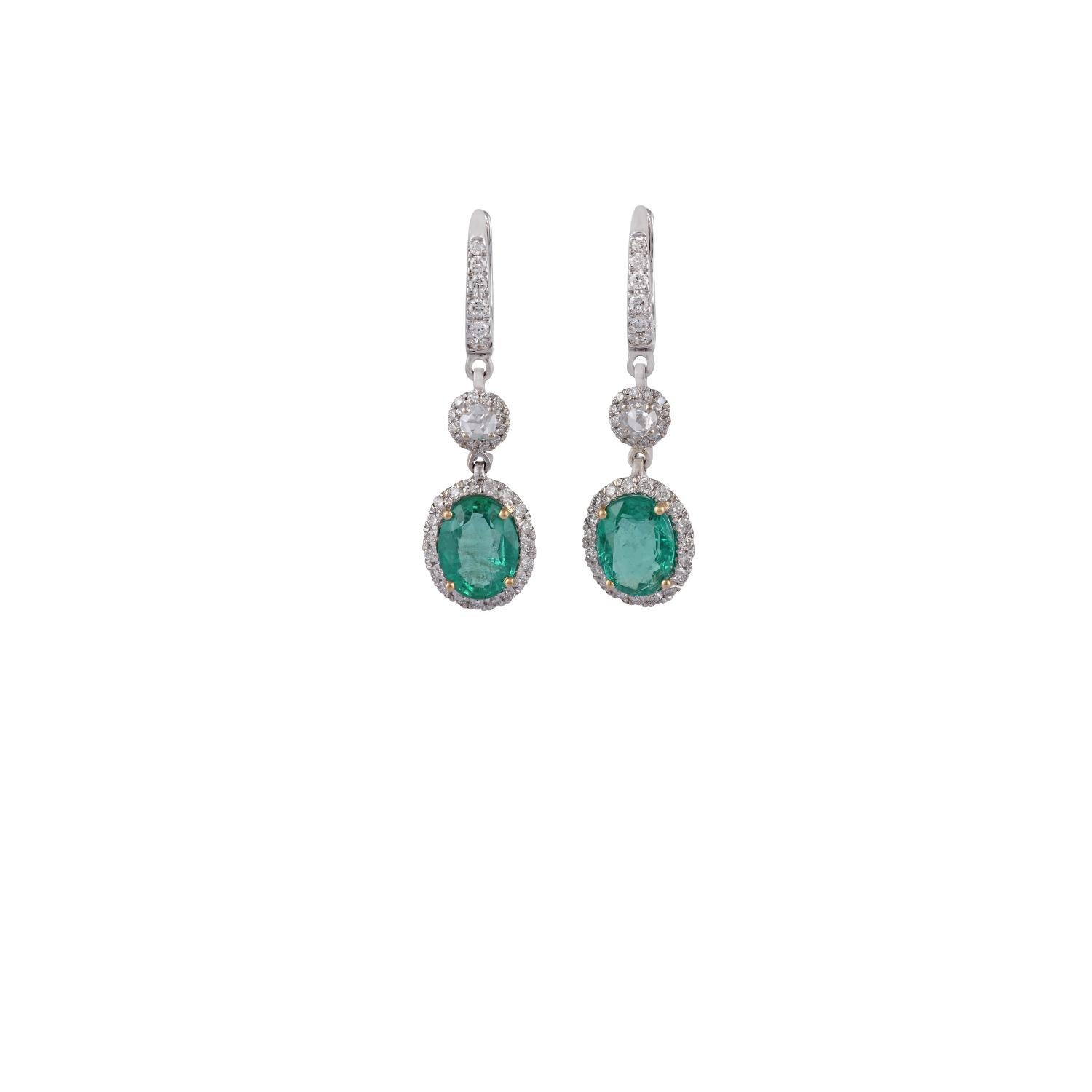 This is an elegant dangle earring pair with emerald & diamonds feature 2 pieces of oval-shaped emeralds weight 3.33 carats, 2 pieces of rose-cut diamonds weight 0.16 carat & 61 pieces of a round brilliant cut diamonds weight 0.65 carats, these