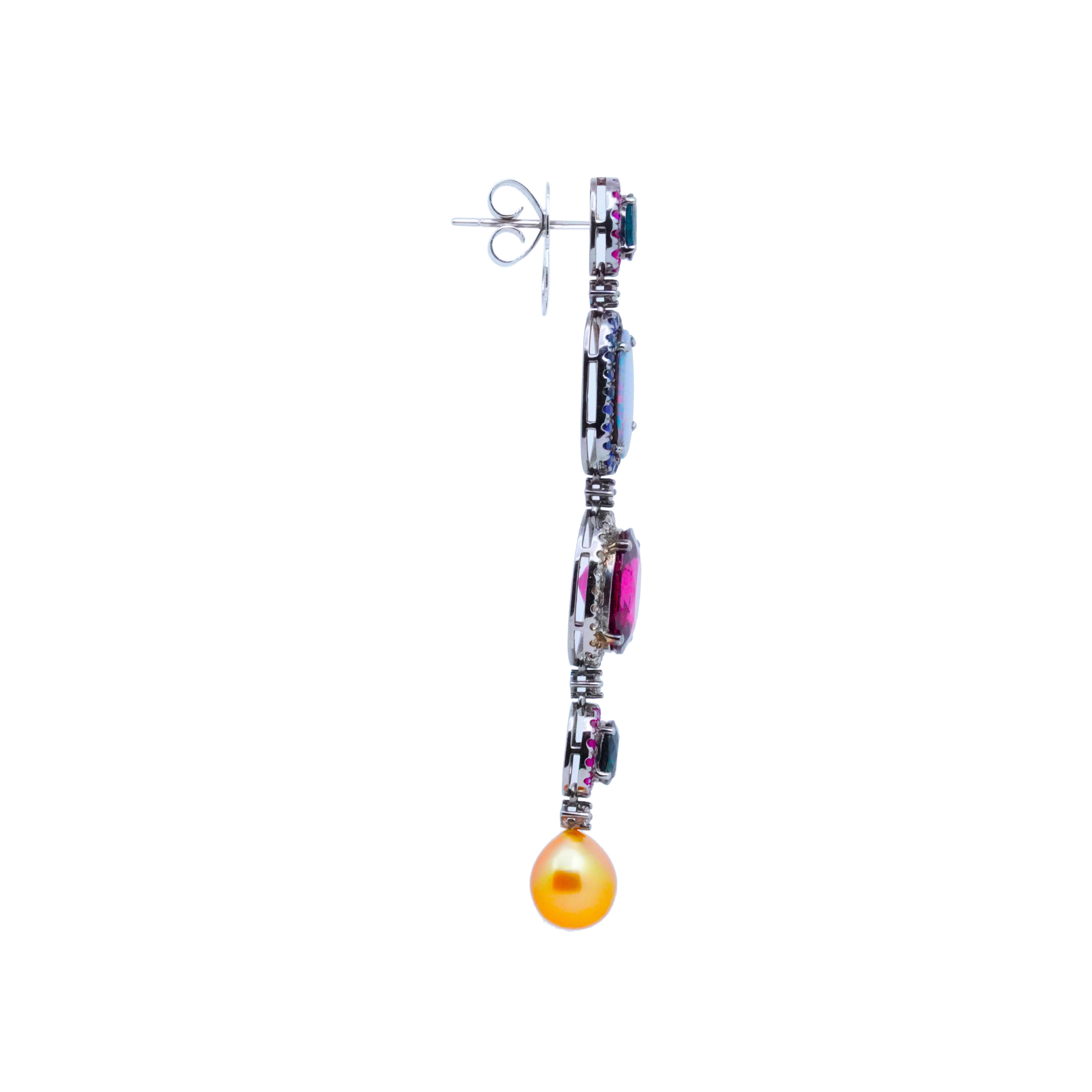Experience the enchantment of these stunning dangling earrings by Austy Lee, a true masterpiece that combines an array of exquisite gemstones. The design showcases a harmonious blend of Blue Sapphires, Opals, Tourmalines, and Southsea Cultured Gold