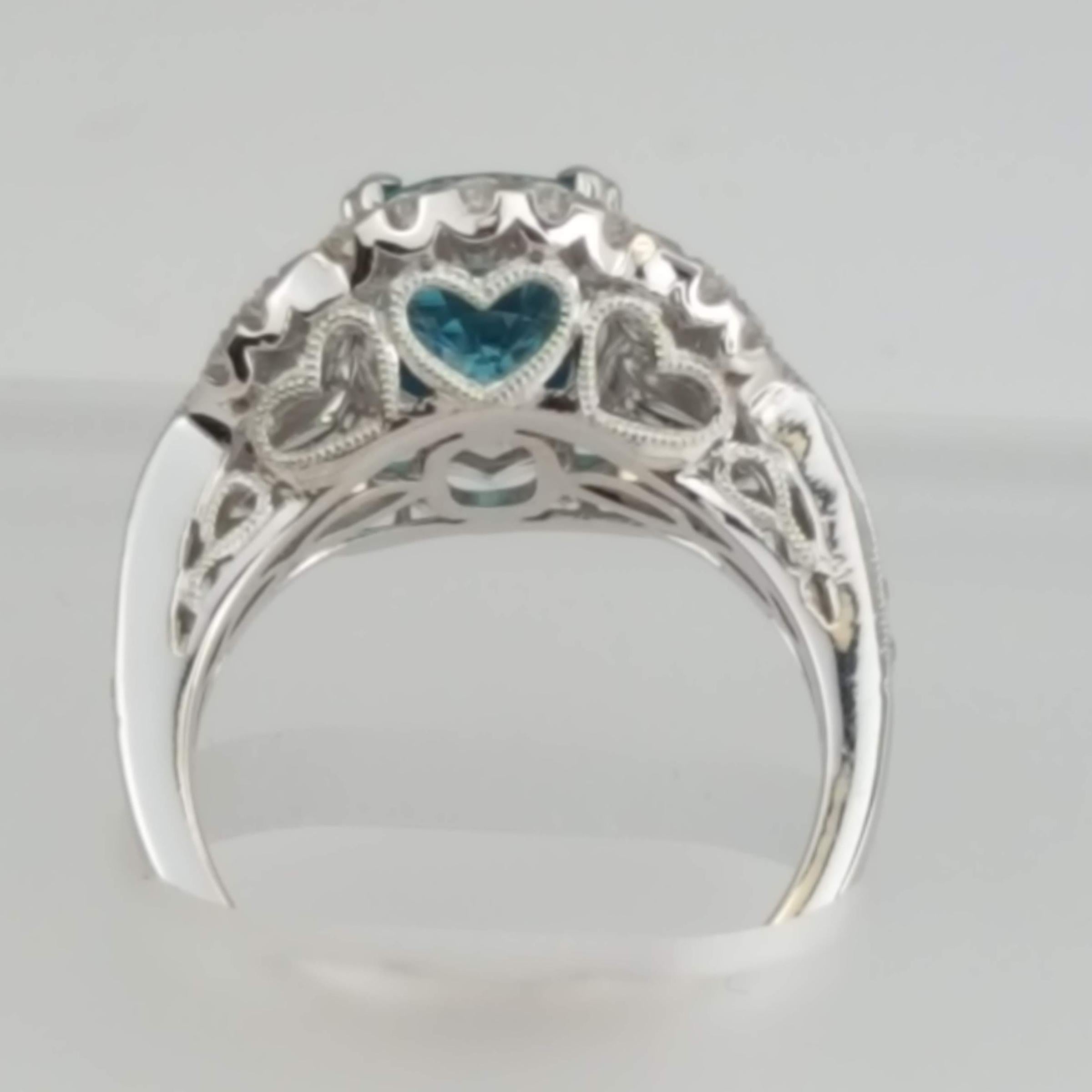 (DiamondTown) With a 3.34 carat oval cut blue zircon center, embellished by 0.61 carats round diamonds, this ring has a simple elegance suited for every occasion. Heart patterns in the decorated under gallery add a romantic touch.

Center: 3.34