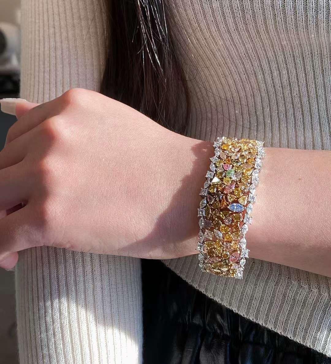 This bracelet features an impressive 33.40 carats of natural colored diamonds, set in solid 18K gold. Each diamond is carefully selected and arranged to showcase a spectrum of rich, natural hues. The diamonds are cut in a variety of shapes to