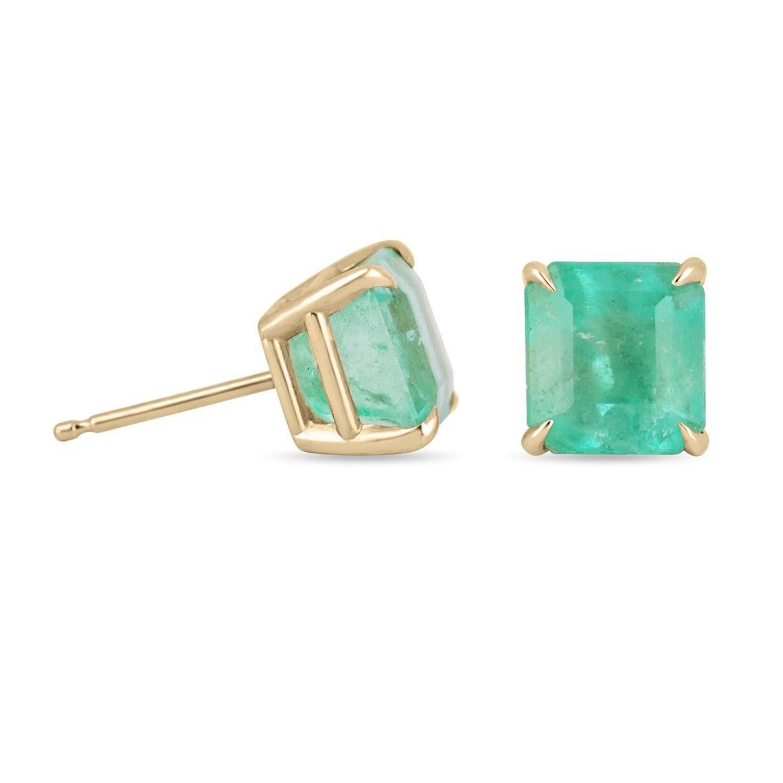 Featured here is a beautiful set of emerald cut Colombian emerald studs in fine 14K yellow gold. Displayed are light-green emeralds with very good transparency, accented by a simple four-prong 14K gold mount, allowing for the emerald to be shown in