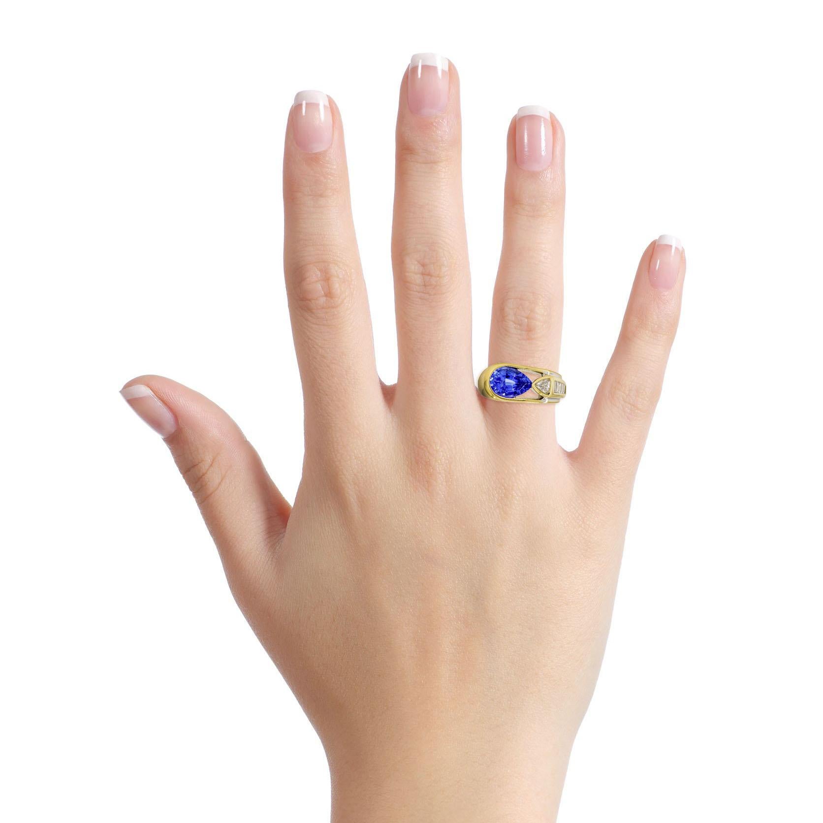 Tanzanite and diamond ring in 18-karat yellow gold. Polished metal setting set with a pear cut natural tanzanite, a trillion cut diamond, and 6 baguette cut diamonds. 

Size, 5.5
Height, 8mm
Width, 8.5mm - 3mm
Depth, 2mm
Weight, 10.3 grams