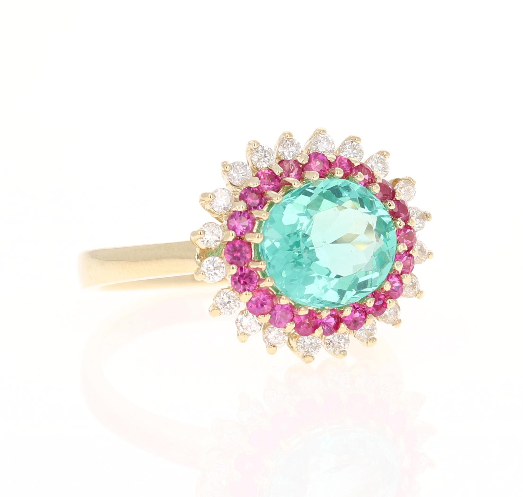 This ring has a 2.56 Carat Oval Cut Apatite in the center of the ring and is surrounded by 20 Pink Sapphires that weigh a total of 0.46 carats and 20 Round Cut Diamonds that weigh 0.33 Carats. The Clarity and Color of the Diamonds is SI-F. The total
