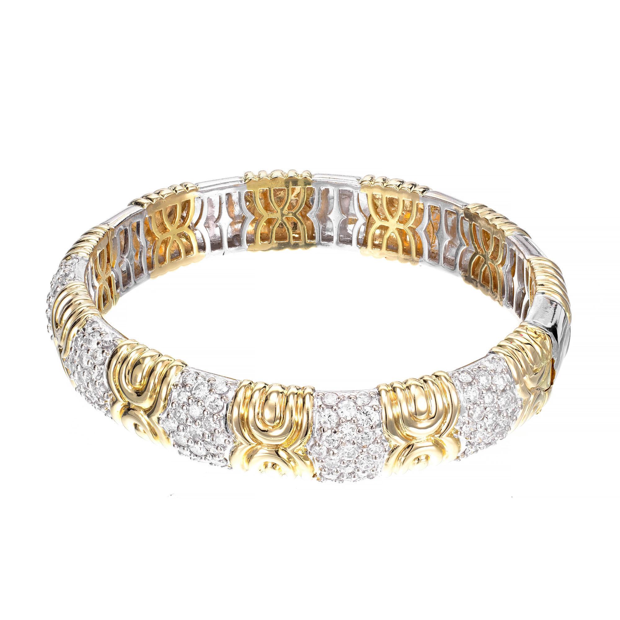 18k yellow and white gold bangle bracelet accented with 95 round brilliant cut diamonds.

95 round brilliant cut diamonds, G-H VS approx. 3.35cts
18k yellow gold 
18k white gold 
Stamped: 750
53.4 grams
Width: 12.6mm 
Thickness/depth: 5.7mm
Inside