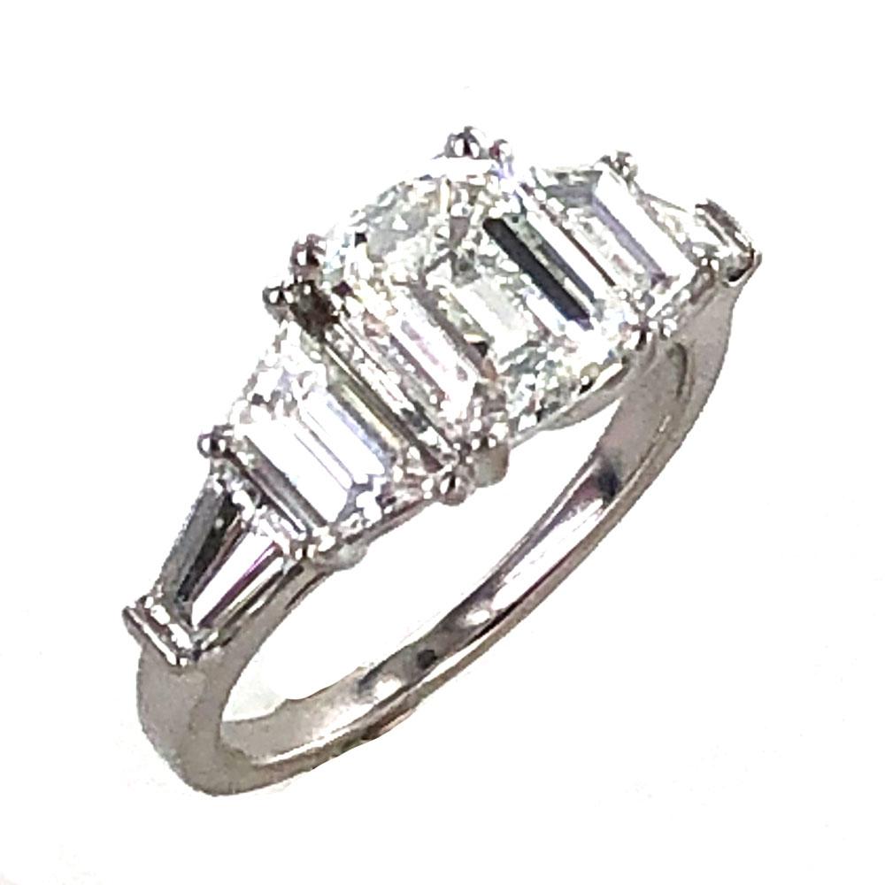 Gorgeous 2.02 carat emerald cut diamond engagement ring crafted with trapezoid and baguette cut side diamonds. The center 2.02 carat emerald cut diamond is graded by the GIA H color and SI1 clarity. The center is flanked by two trapezoid and two