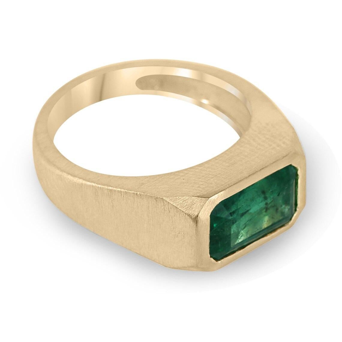 This stunning natural emerald ring features an elongated emerald cut emerald set east to west, creating a modern and sophisticated look. The emerald's rich green color and natural inclusions are on full display, making for a truly unique piece. The