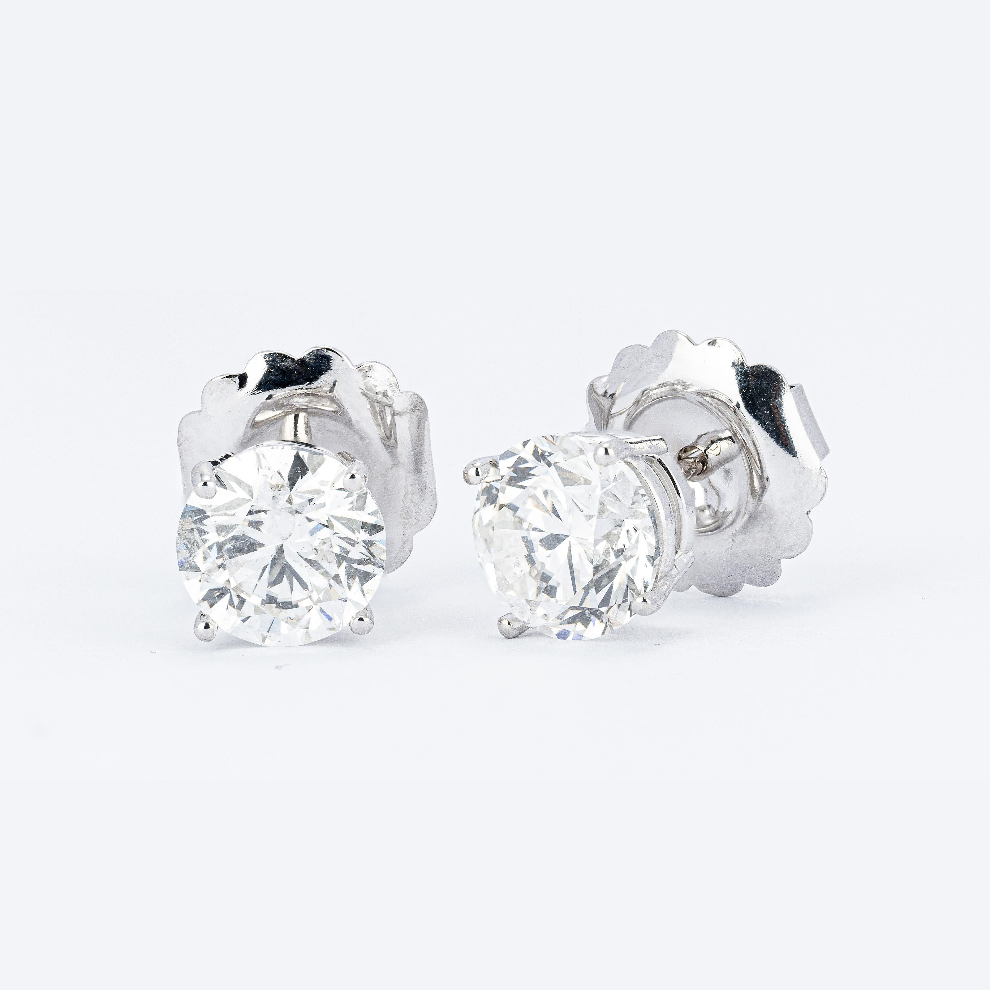 Aquí tienes un par de magníficos pendientes de diamantes de talla redonda, ideales para cualquier ocasión. Innegablemente deslumbrantes, estas tachuelas te ayudarán a destacar entre la multitud en cualquier entorno. Captar la mirada de