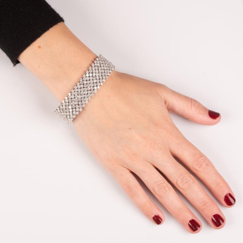 This exquisite diamond mesh bracelet features five elegant rows of round diamonds totaling 33.68 carats, set in luxurious 18K white gold. With a secure sliding lock clasp and a comfortable 7-inch length, it's a perfect accessory for any