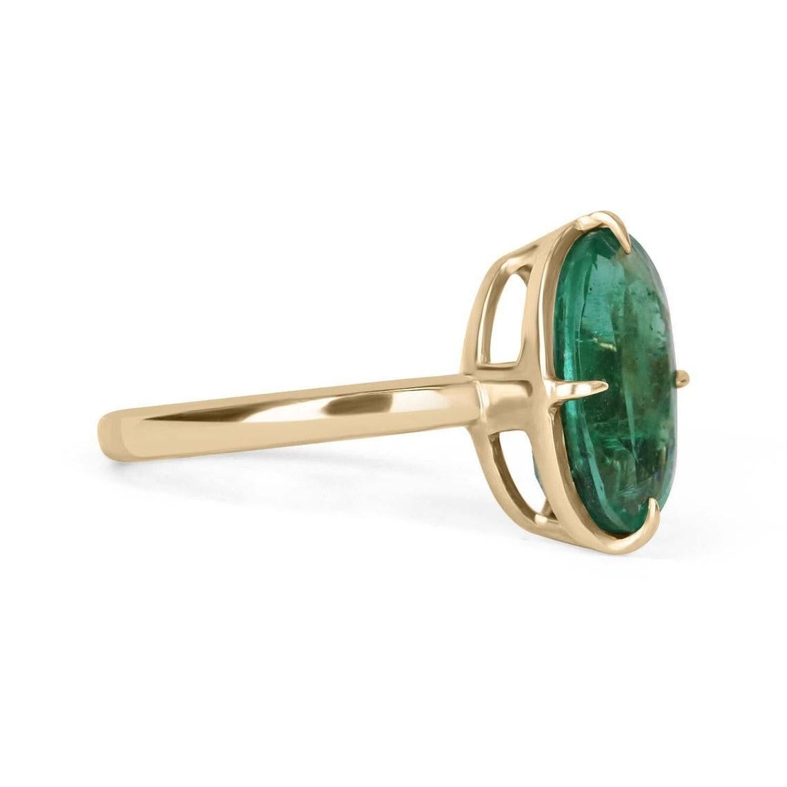 Displayed is a custom emerald solitaire oval-cut engagement/right-hand ring in 14K yellow gold. This gorgeous solitaire ring carries a 3.36-carat emerald in a prong setting. The emerald has very good clarity with minor flaws that are normal in all