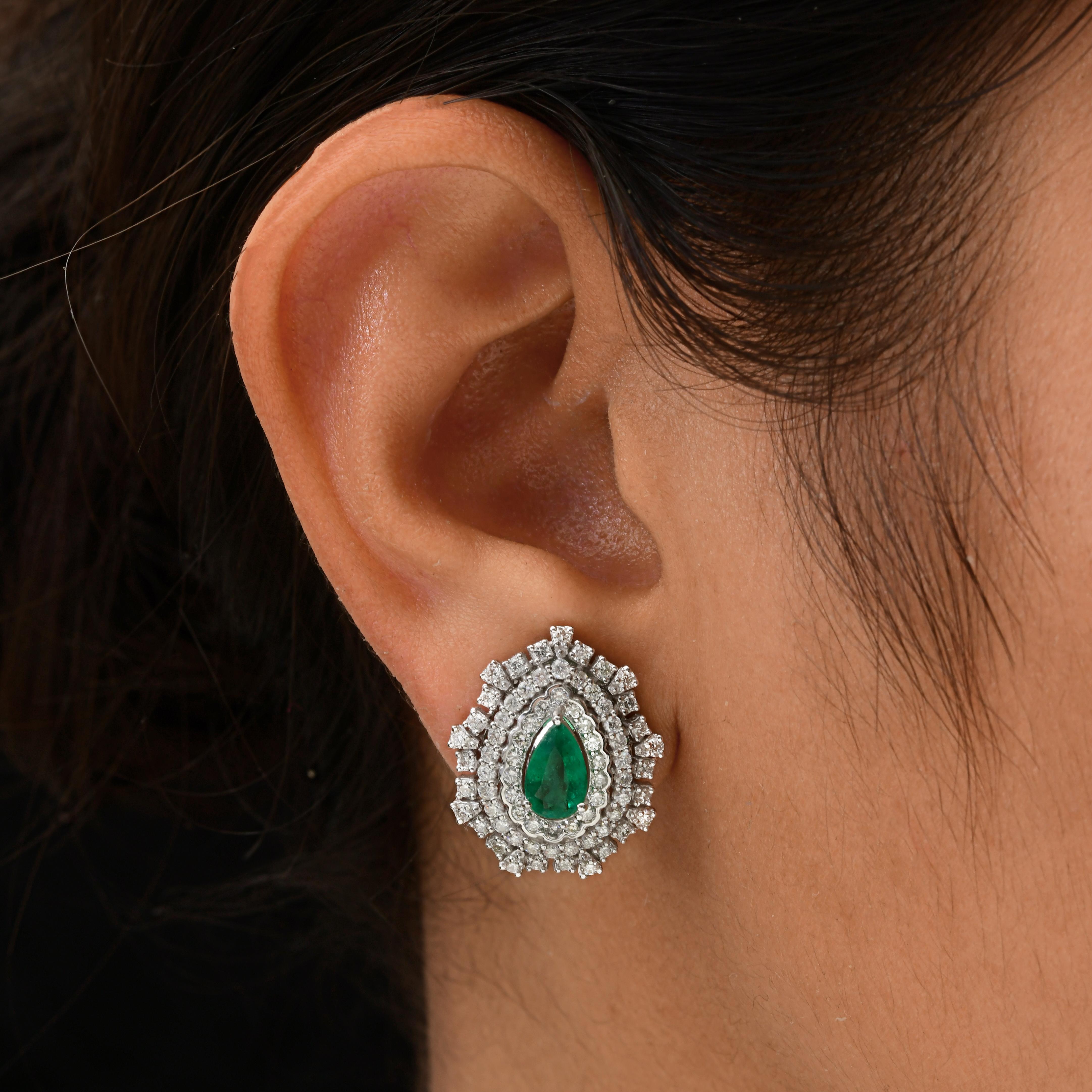 3,36 Tcw sambischen Smaragd Halo Rundschliff Diamant Braut Ohrstecker 18K Gold.
Das Herzstück dieser atemberaubenden Ohrringe ist ein leuchtender Smaragd im Birnenschliff, der eine tiefe, satte grüne Farbe aufweist. Jeder zentrale Smaragd ist von