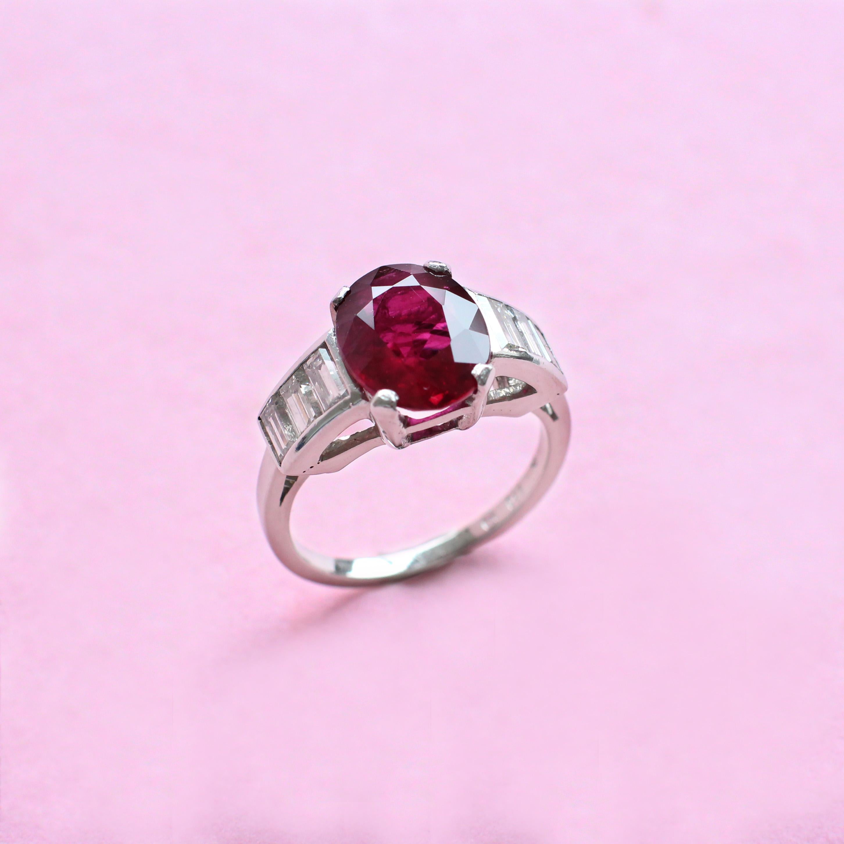 The elegant oval ruby at the centre of this arresting ring was hand-picked from the Haruni vault and boasts a deep, rich red colour. It sits on an exquisite platinum band and is supported on each side by sparkling white baguette diamonds, whose