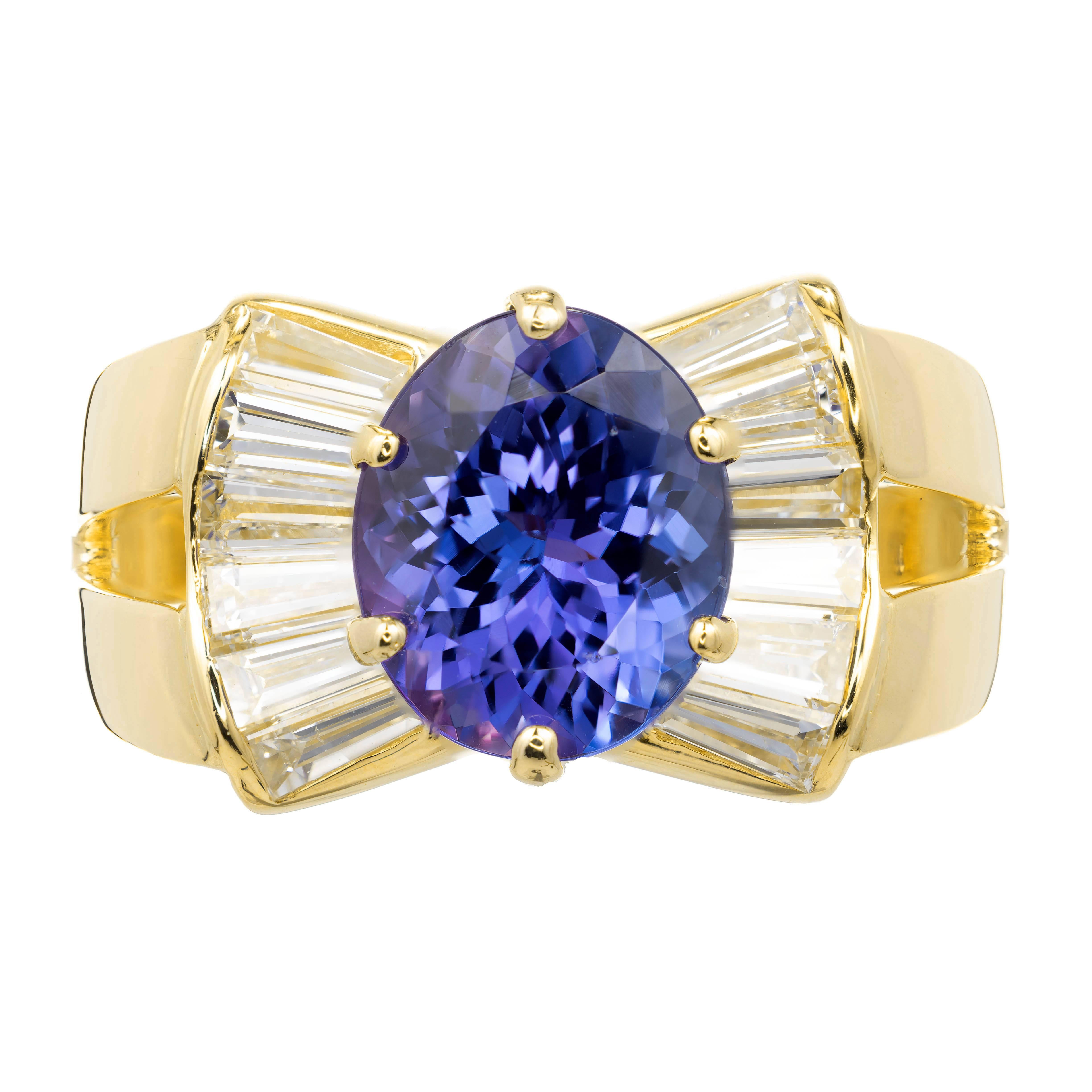 Tanzanite and diamond cocktail ring. Well-polished 3.38ct oval tanzanite in a 18k yellow gold setting with tapered baguette side diamonds. 

1 oval purplish blue Tanzanite, approx. total weight 3.38cts, VS
12 tapered baguette diamonds, approx. total