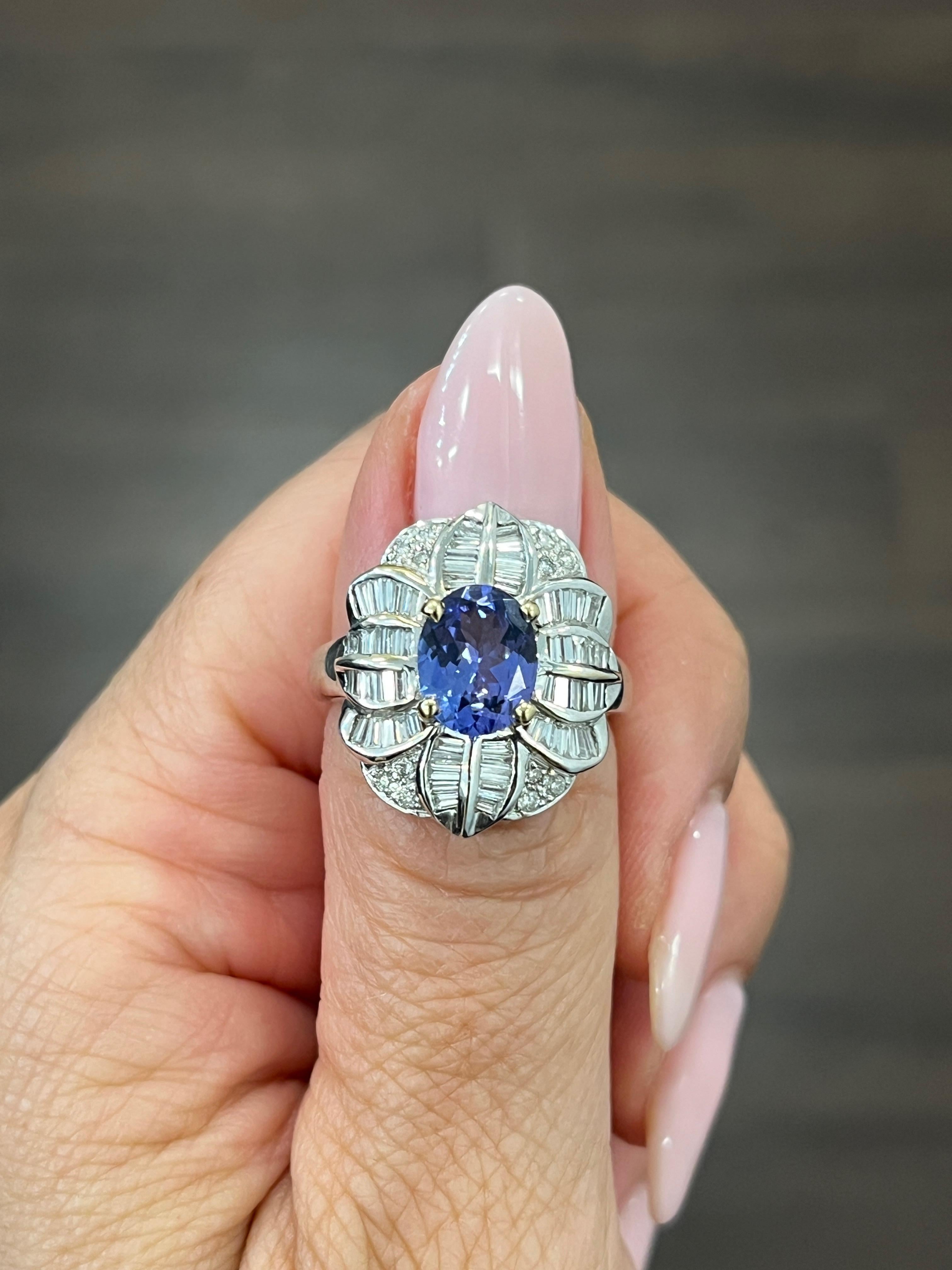 This stunning ring features a beautiful oval tanzanite gemstone in a striking blue color, surrounded by sparkling diamonds. The ring is crafted from high-quality 14k white gold and is sizable to fit a ring size of 7.25. The total carat weight of the