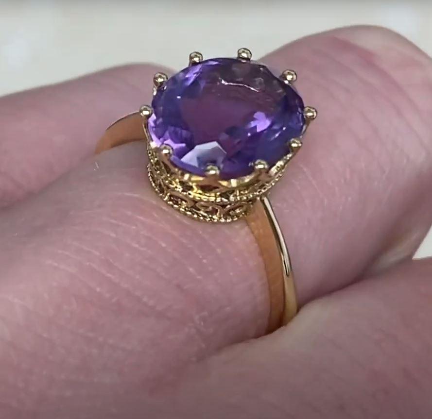This exquisite antique-style ring showcases a breathtaking natural amethyst center stone, weighing approximately 3.30-carats. The amethyst's deep, regal hue is beautifully complemented by its expert faceting, which enhances its brilliance and depth.