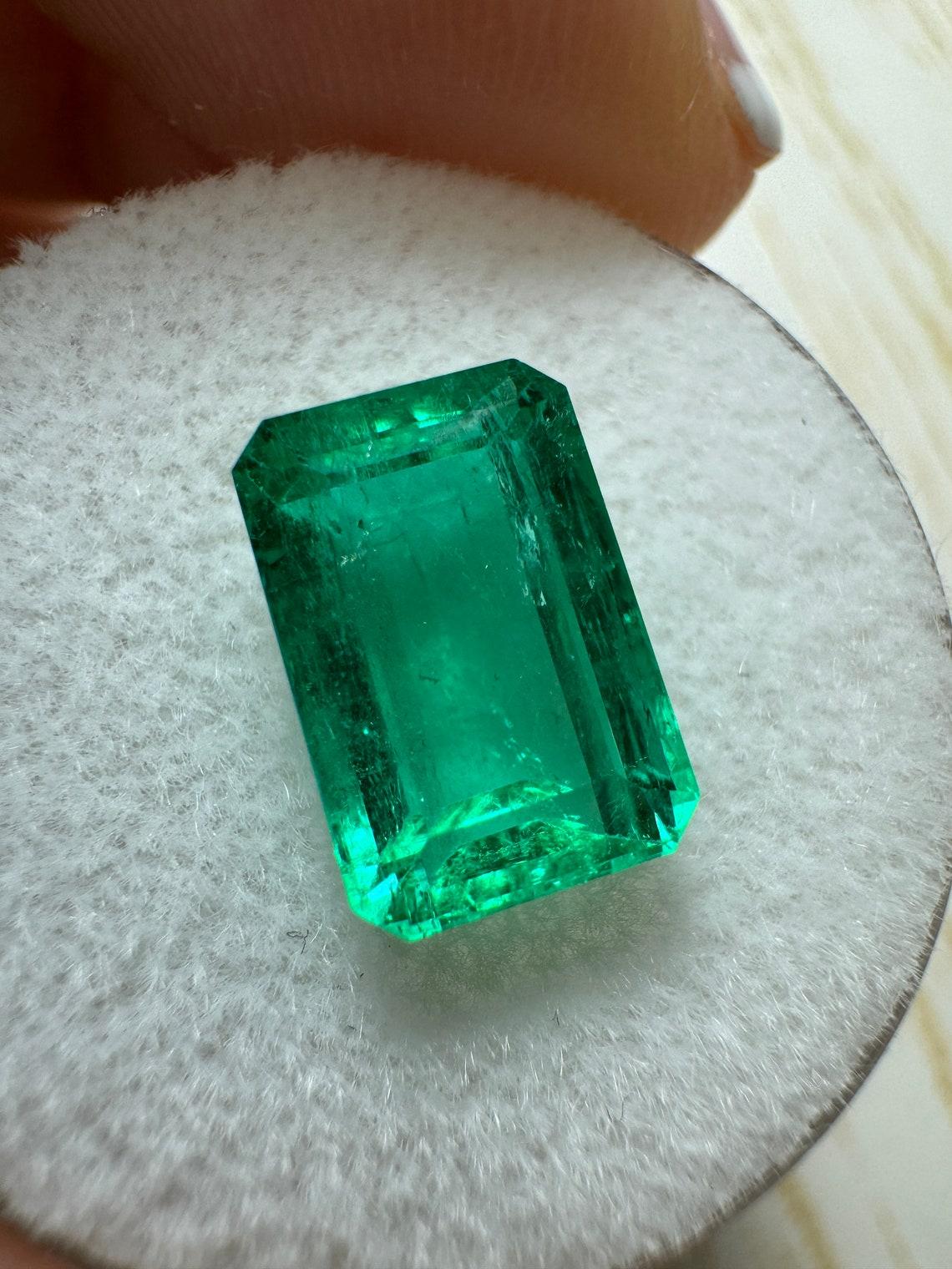 Stone: Emerald
Weight: 3.39-carats
Shape: Emerald Cut
Clarity: Transparent
Luster: Excellent
Color: Vivid Bluish Green
Measurements: 10.79mm x 7.19mm x 5.31mm
Geographic Origin: Colombia
Treatment: Natural, Oiling

Comments: Due to their growth