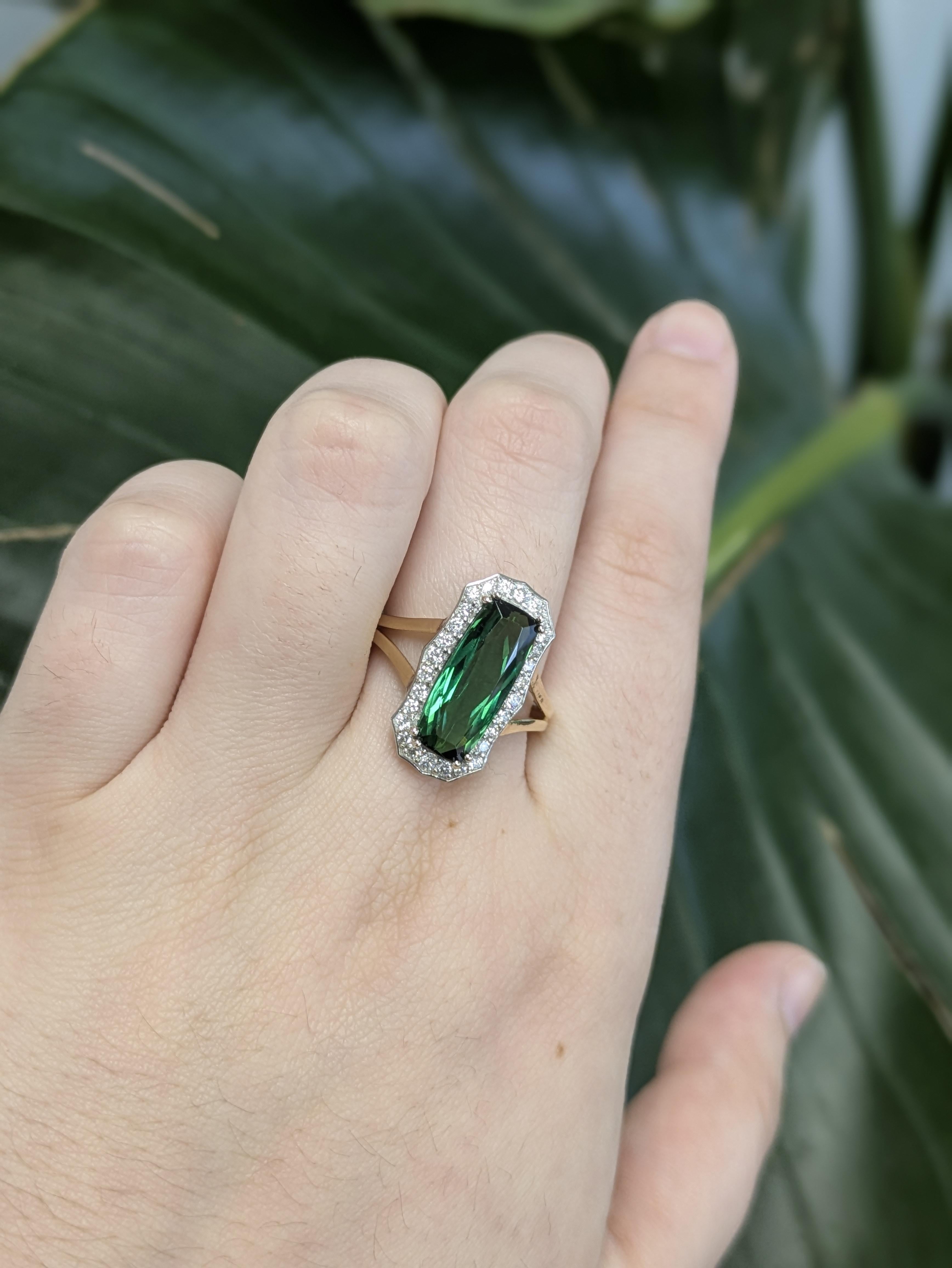 Con una fascinante turmalina indicolita AAA de 3,31 ct procedente de Brasil, este anillo presenta una llamativa piedra central talla esmeralda de 15,5x6,4 mm. Engastado en oro de 14k (3,77 g), está bellamente realzado con 18 diamantes brillantes que