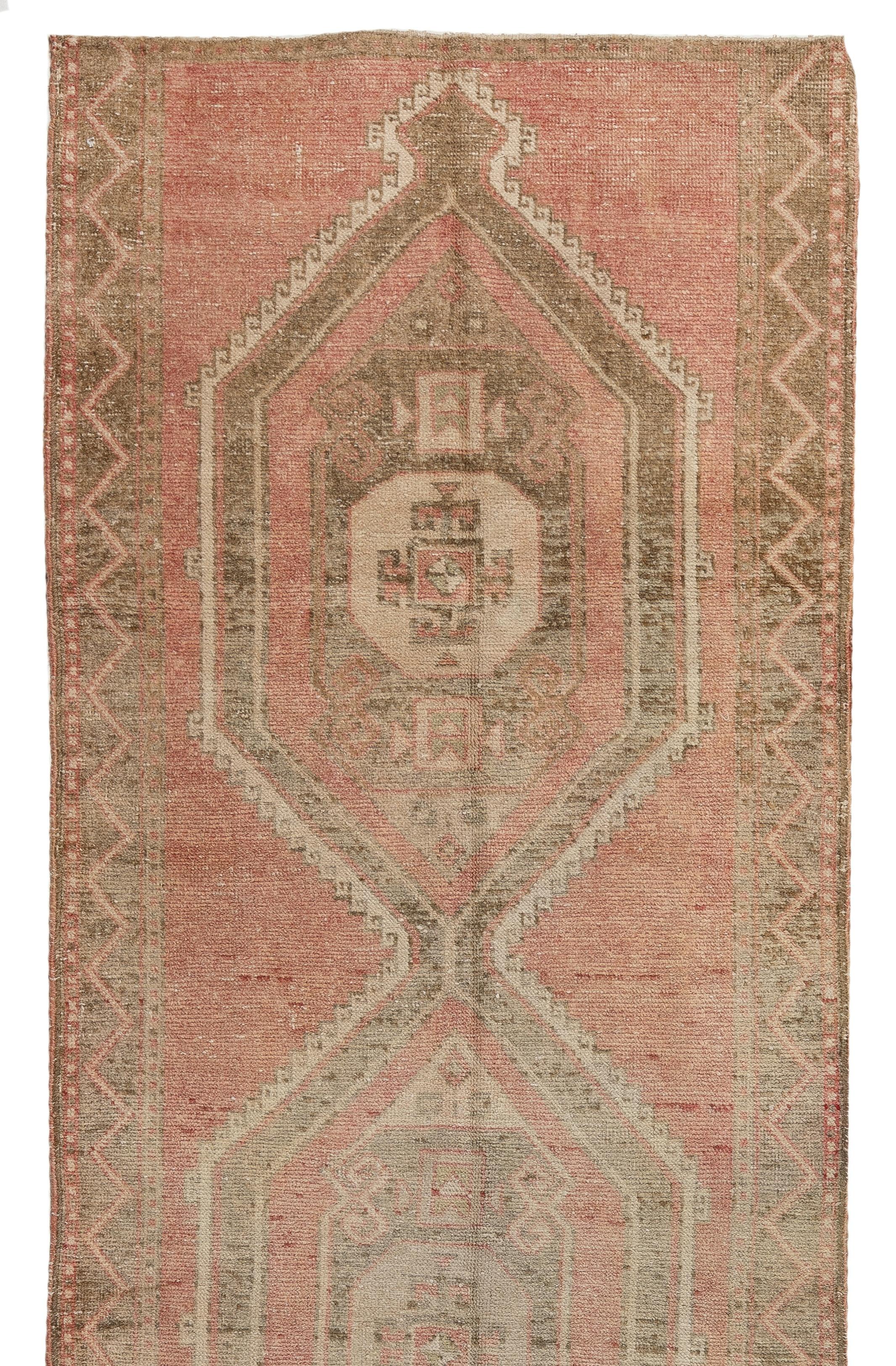 This vintage hand-knotted runner rug was made in Central Turkey in the 1960s. It is made of medium wool pile on wool foundation and features a geometric design in soft colors. It has been washed professionally, The rug is sturdy and can be used in