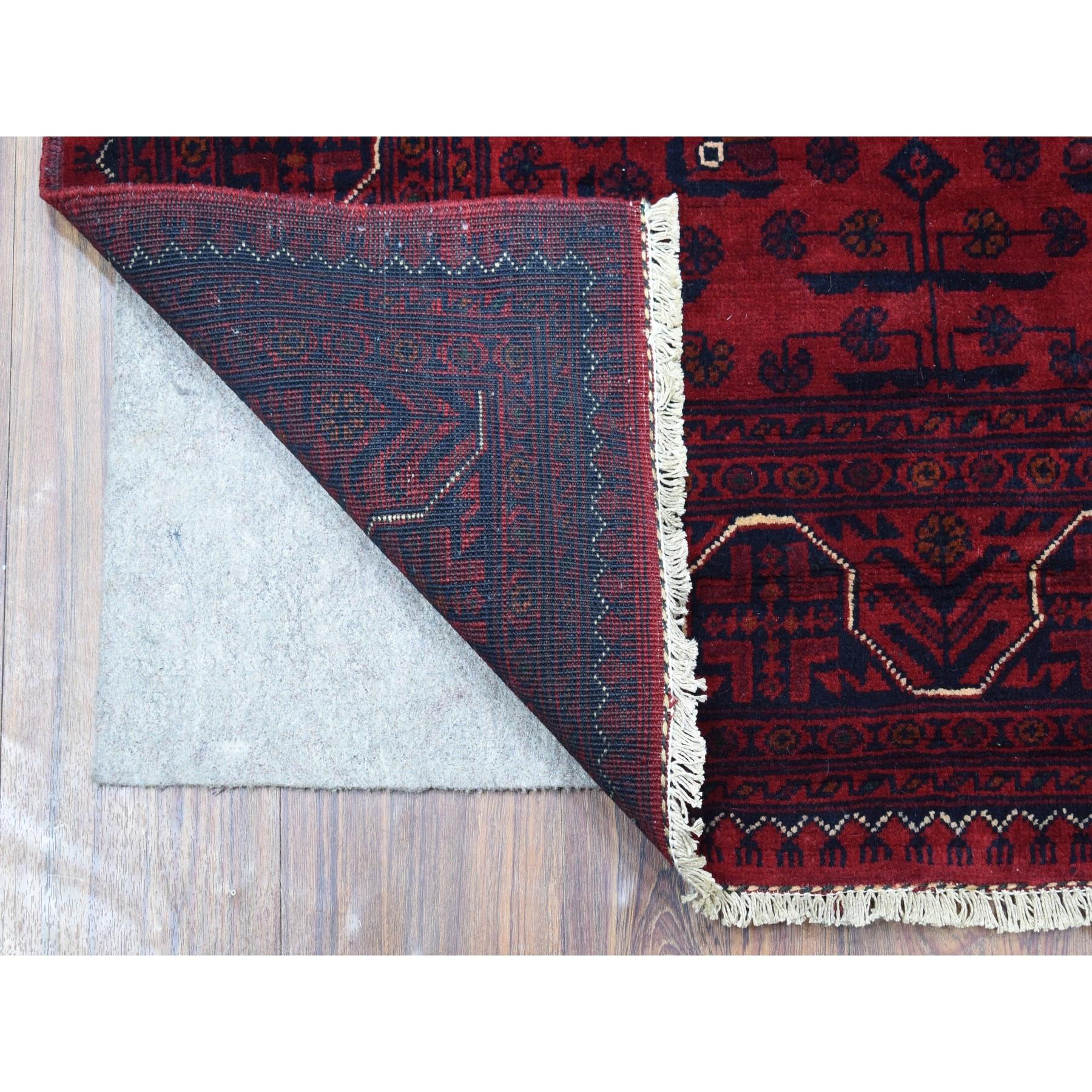 Il s'agit d'un véritable tapis d'Orient Khamyab afghan à double médaillons, en pure laine, noué à la main, d'un rouge profond et saturé. Il a été noué pendant des mois et des mois selon des techniques de tissage séculaires par des artisans