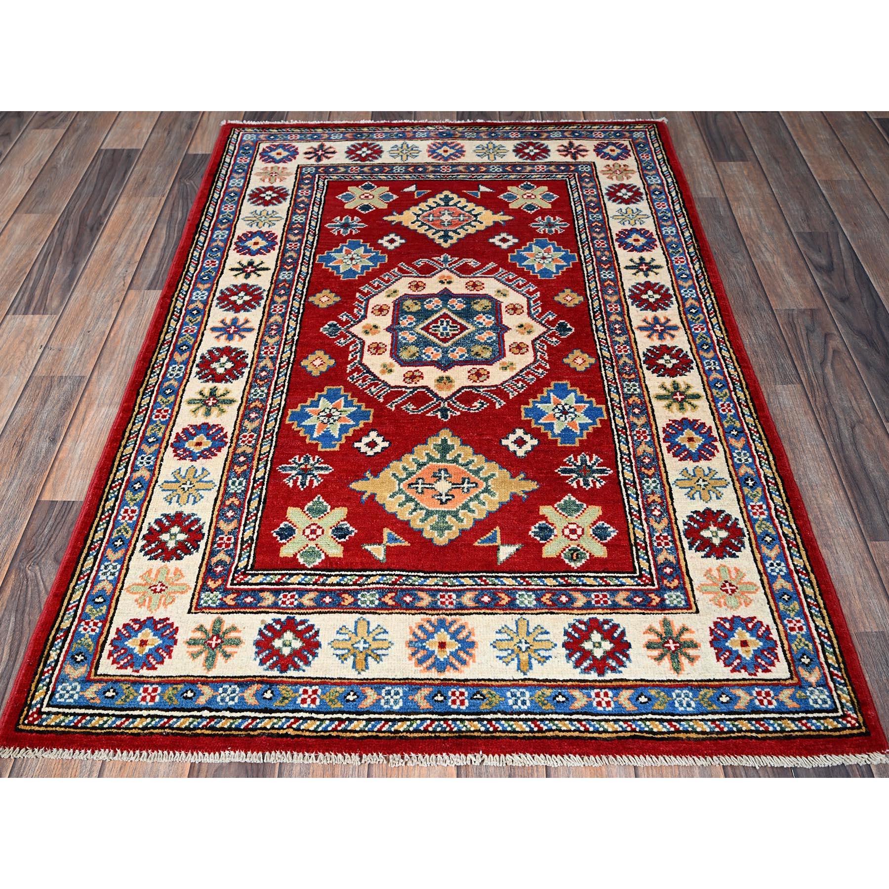 Karmesinrot, Kazak mit geometrischem Medaillon-Design, Pflanzenfarben, handgeknüpft, dichtere Webart, reine Wolle, Orientteppich
Primäre MATERIALIEN: Wolle
Latex: Kein Flor 
Höhe: 0,25 Zoll
Stil: Traditionell
Grundfarbe: Rot
Sekundäre Farben: Beige,