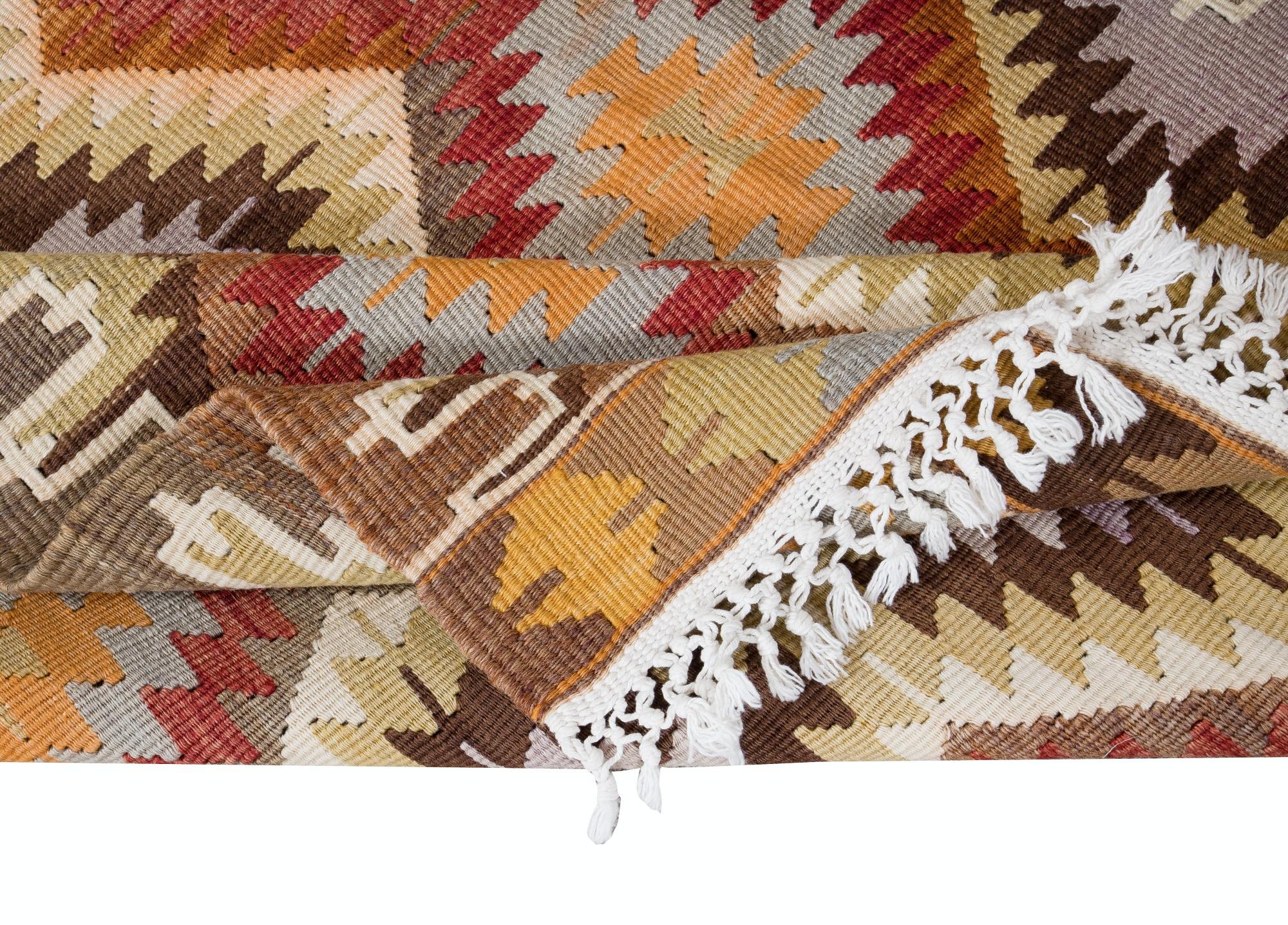 Embarquez pour un voyage à travers la tradition turque avec cet exquis tapis kilim vintage en laine turque tissé à la main, qui témoigne du savoir-faire durable des artisans d'Anatolie. Tissé avec un soin méticuleux et une attention particulière aux