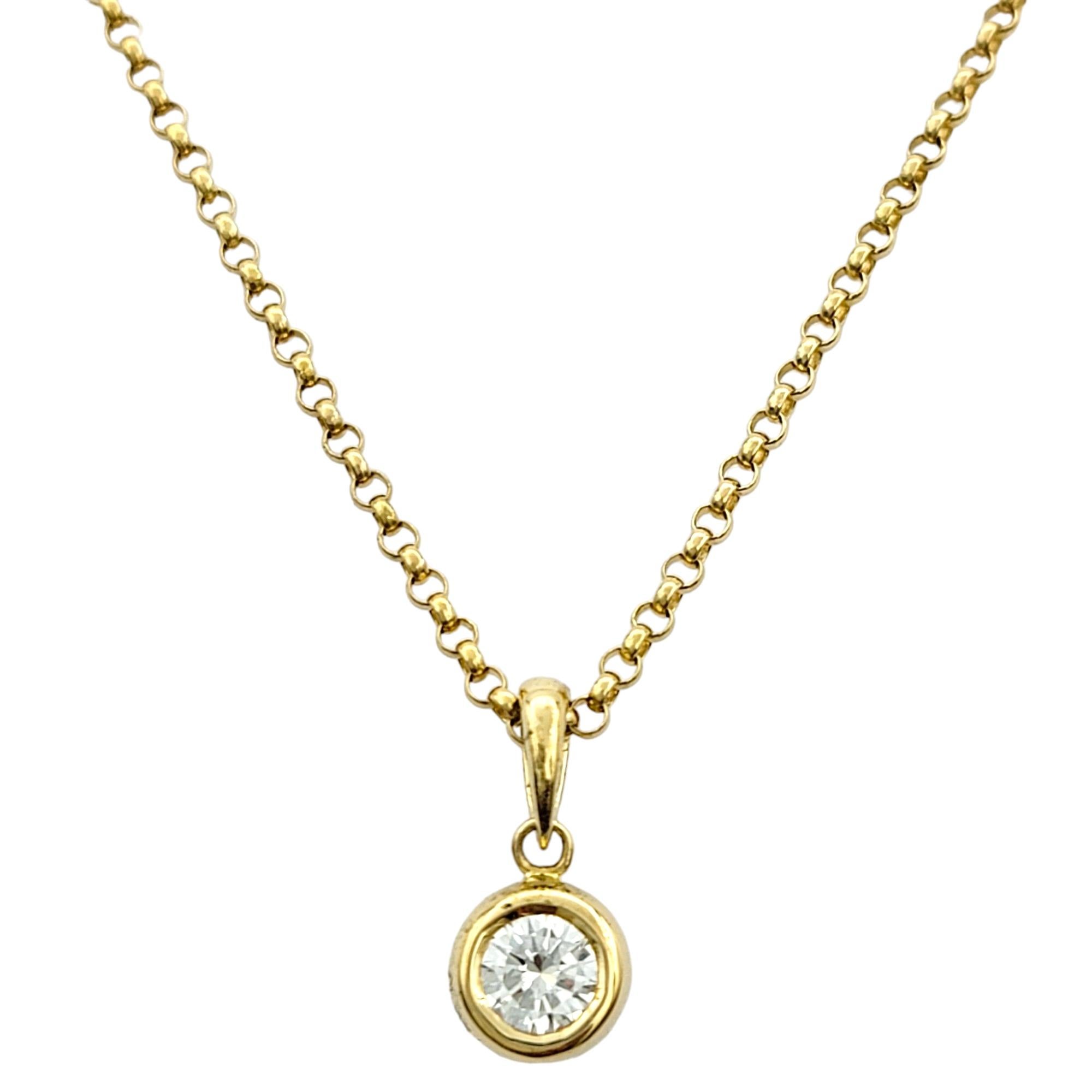 Crafted with timeless elegance, this solitaire diamond pendant necklace exudes sophistication and refinement. The pendant features a single round diamond, securely nestled within a sleek bezel setting made of lustrous 18 karat yellow gold. The bezel