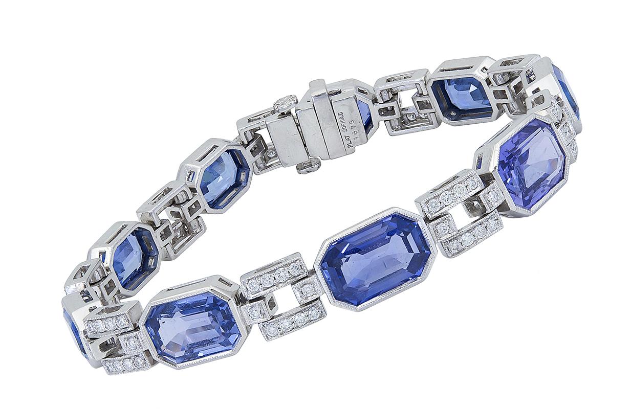 This bracelet features emerald cut blue sapphires spaced by diamond encrusted links set in 18k white gold. 
Blue sapphires weigh 34 carats total.
Diamonds weigh 1.26 carats total.
7.25 inches (length) x 0.67 inches (width)