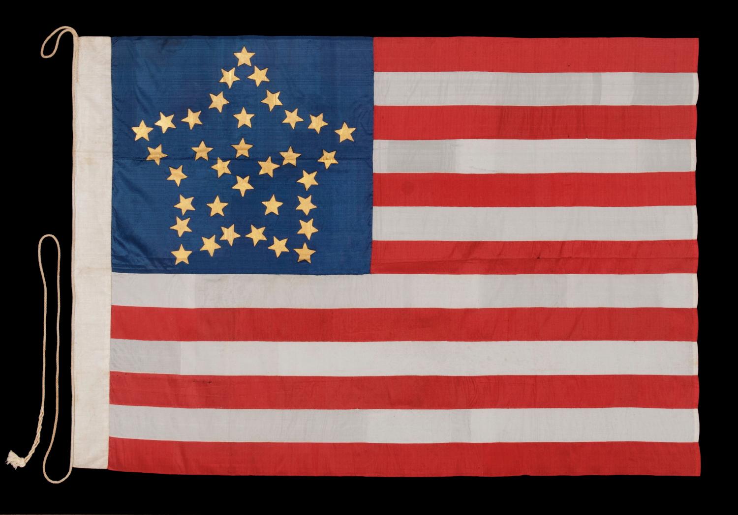 34 GILT PAINTED STARS IN A BOLD REPRESENTATION OF THE “GREAT STAR” PATTERN, ON A SILK, ANTIQUE AMERICAN FLAG MADE DURING THE OPENING YEARS OF THE CIVIL WAR, 1861-63, PROBABLY MADE UNDER MILITARY CONTRACT OR FOR USE BY LOCAL MILITIA, ENTIRELY