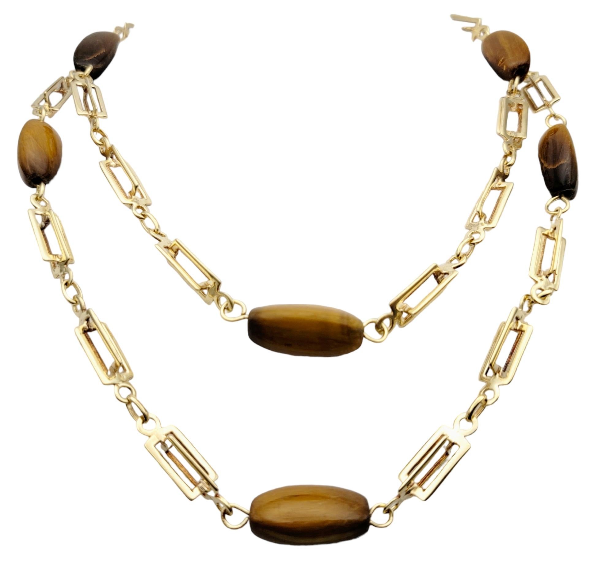 Contemporary elongated gold station necklace with lustrous Tiger's eye stones throughout. Long and luxurious, this modern necklace is a unique and fashionable piece you will wear again and again. 
 
This eye-catching necklace features a polished 14