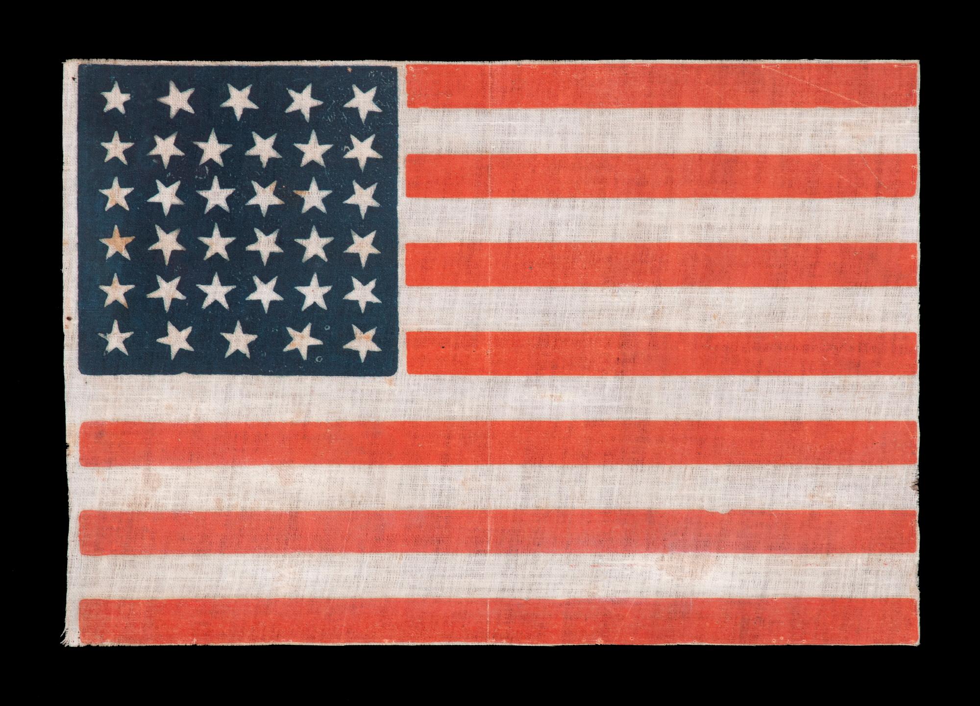 34 STARS, WITH SCATTERED POSITIONING, ON AN ANTIQUE AMERICAN PARADE FLAG MADE DURING THE OPENING TWO YEARS OF THE CIVIL WAR, 1861-63, KANSAS STATEHOOD

34 star American national flag, printed on glazed cotton. Kansas was admitted into the Union as
