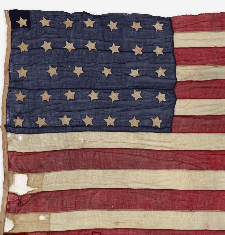 Offered is a large 34-star flag, produced during the Civil War. This flag features white double-appliqued hand and machine-sewn stars on a blue canton, along with 13 machine-sewn alternating red and white stripes. The stars are arranged in rows of