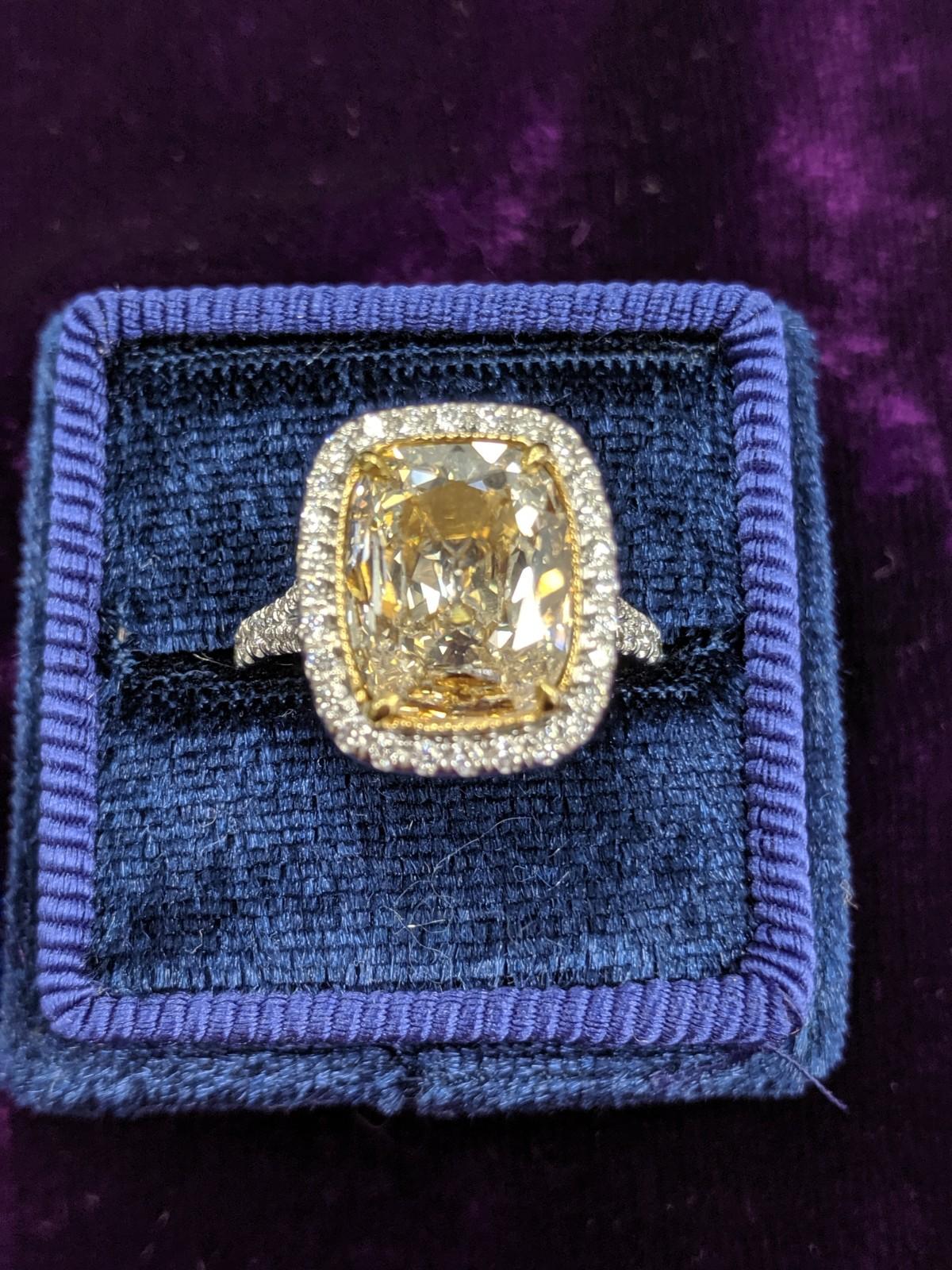 This 3.40 carat light yellow diamond ring has the large natural diamond look you want with important presence.  The center cushion cut diamond spreads 11.52 x 9.30mm and is set in 18 carat white and yellow gold to bring out the natural light yellow