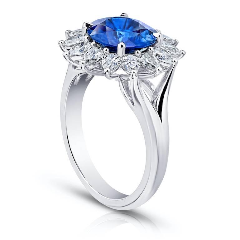 3.40 carat round blue sapphire surrounded by 14 pear shape diamonds weighing 1.30 carats set in custom hand made platinum ring.
