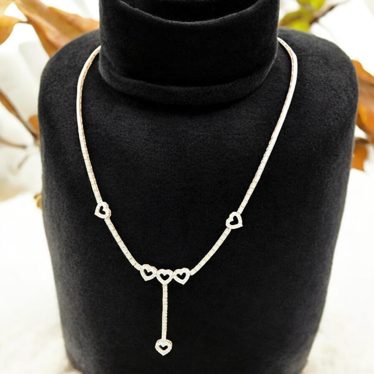 Parure exquise en diamants, comprenant un ensemble de boucles d'oreilles et un collier, dans un design romantique.
Ajoutez une touche de lumière et de sophistication sur vous-même.
Cette magnifique parure en or 14k est ornée de diamants naturels de