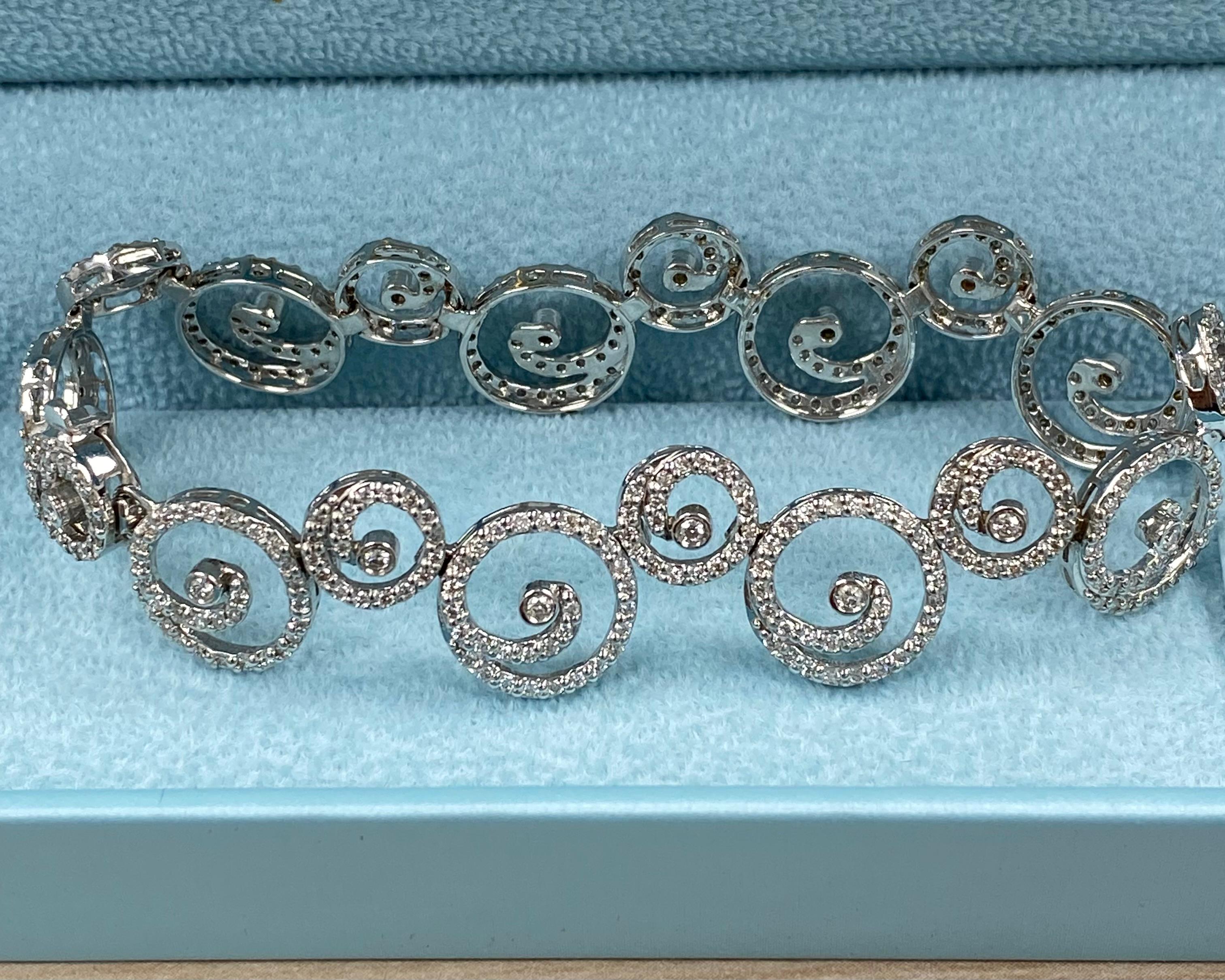 Esta impresionante pulsera presenta un moderno diseño en espiral, con 3,40 quilates de diamantes naturales de talla redonda, de color H/I y claridad SI/I, engastados en un deslumbrante pavé. Elaborada en oro blanco de 14 quilates, esta elegante