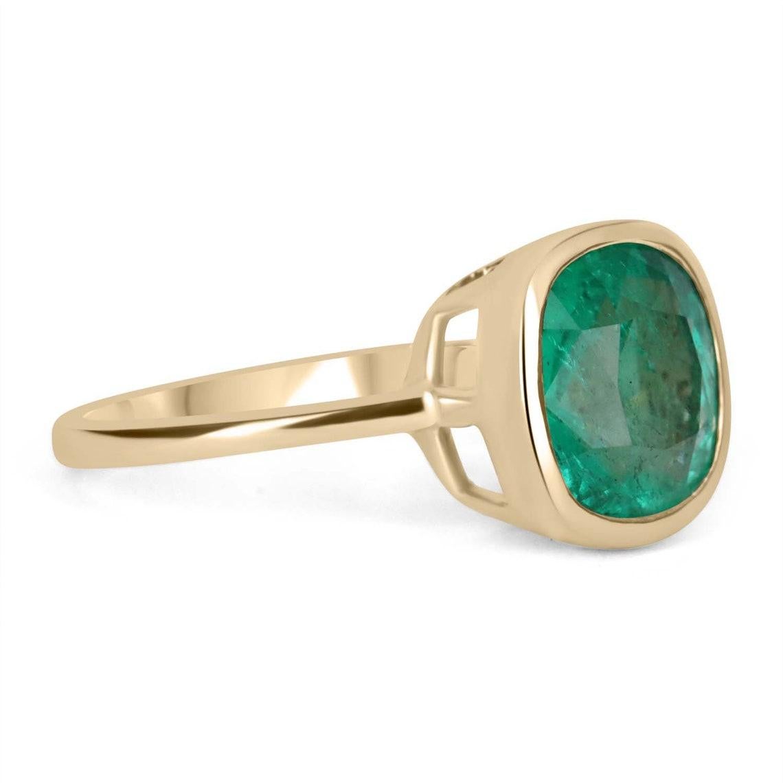 Displayed is a bespoke Colombian emerald solitaire cushion-cut engagement/right-hand ring in 18K yellow gold. This gorgeous solitaire ring carries a 3.40-carat emerald in a bezel setting. Fully faceted, this gemstone showcases excellent shine. The