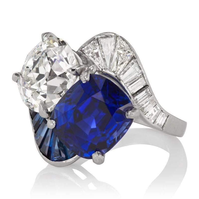 This ring is an authentic vintage diamond and sapphire ring from the Art Deco Era circa 1920. The ring centers two gorgeous stones, one being a GIA-certified 3.41-carat old mine cut diamond of J color, SI1 clarity. The second center stone is an AGL