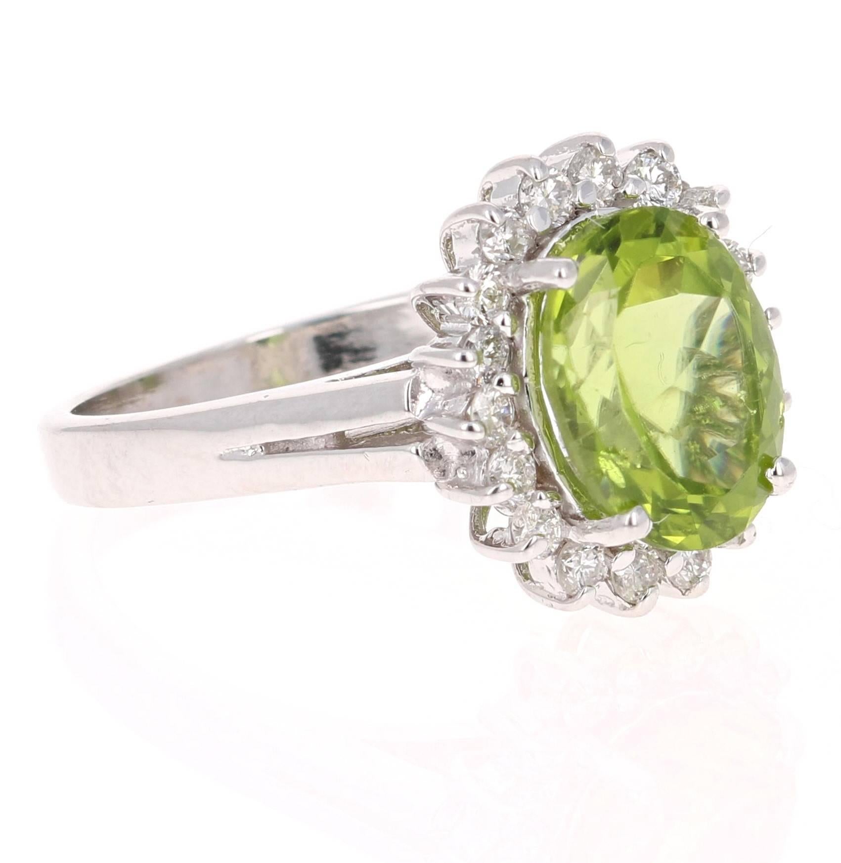 This beautiful ring has a Oval Cut Peridot in the center that weighs 2.99 carats. The ring is surrounded by a cute halo of 18 Round Cut Diamonds that weigh 0.42 carats. The total carat weight of the ring is 3.41 carats. The setting is crafted in 14K
