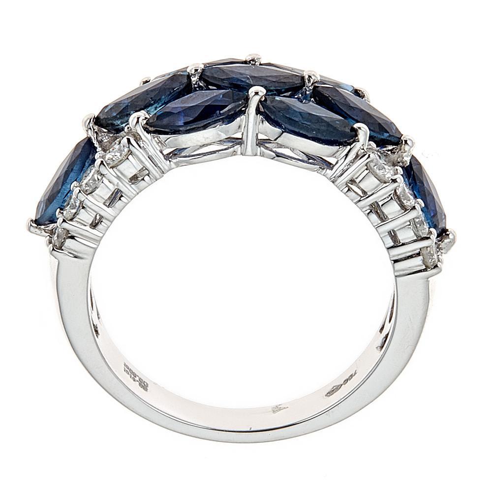 This handmade 18K white gold ring showcases marquise-cut sapphires and round brilliant diamonds.