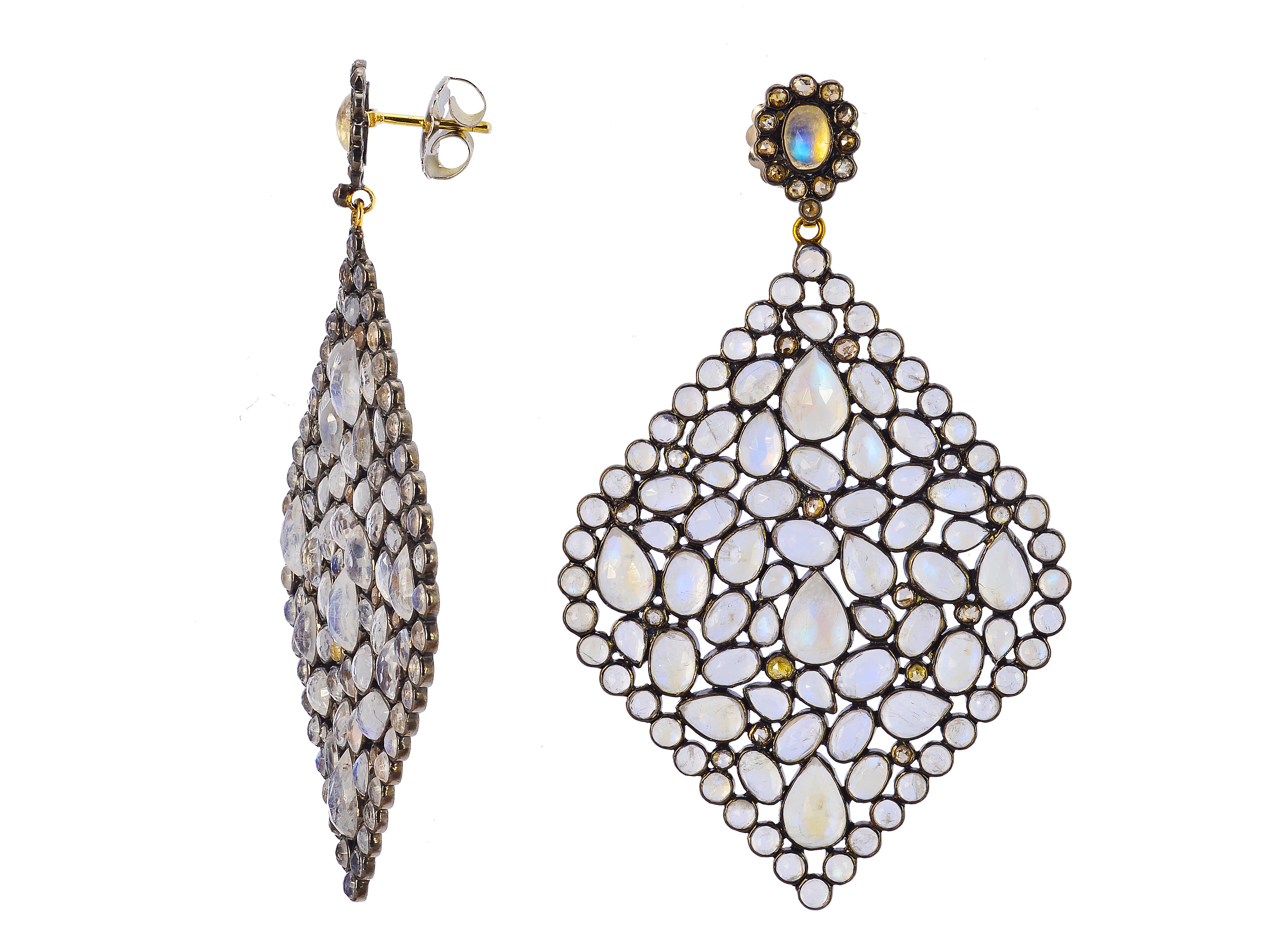 Sterling silver and 18 karat yellow gold statement earrings containing 34.10 carats of bezel-set moonstones. The clear gem stones have a blue adularescense, which is an optical sheen visible when light hits from the front. Post and large, supportive
